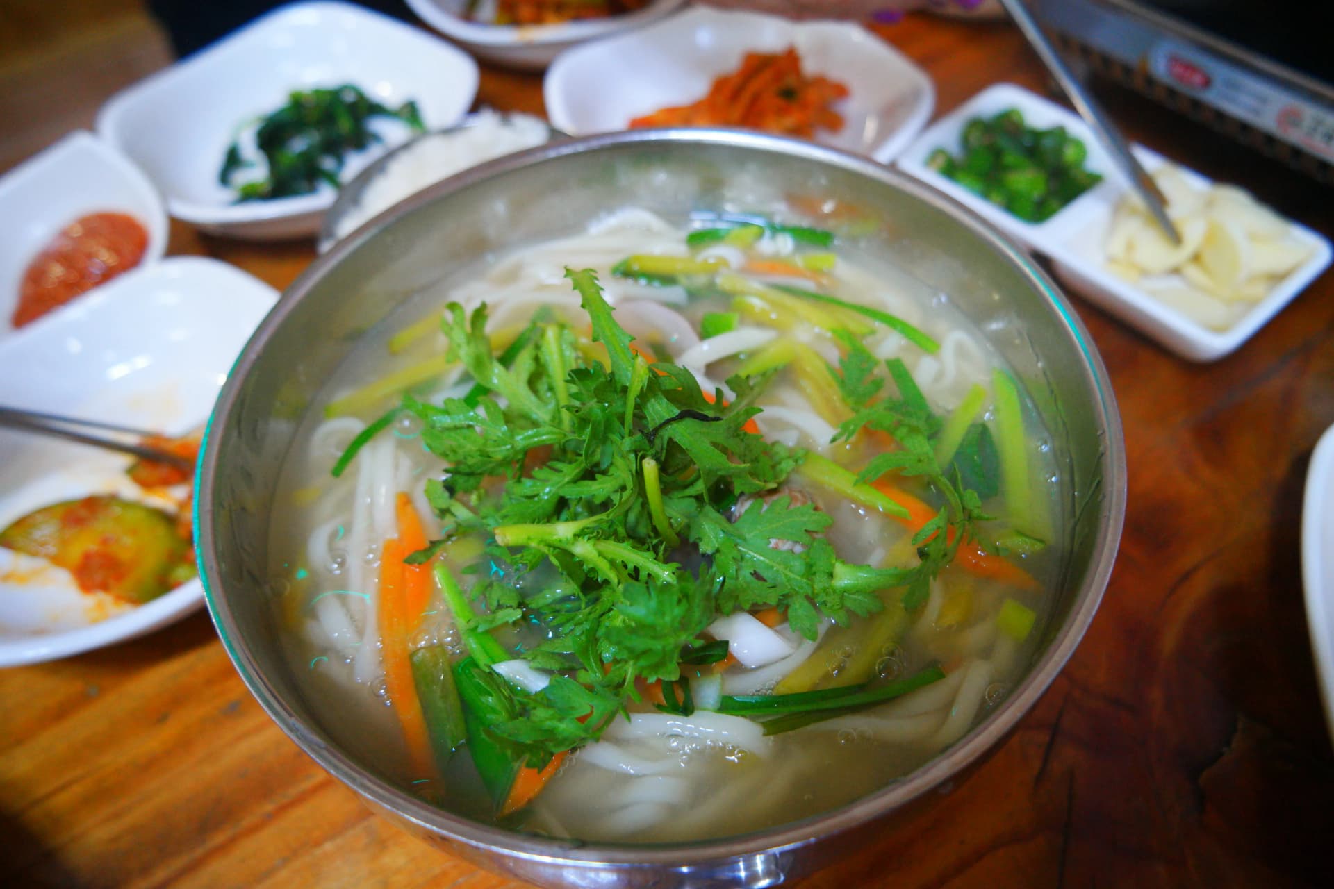 Нэг аяга калгүксү - тунгалаг шөлөн дээр ссүггат, лууван, ногоон хулуу тавьсан солонгос гар хэрчсэн гоймонтой шөл