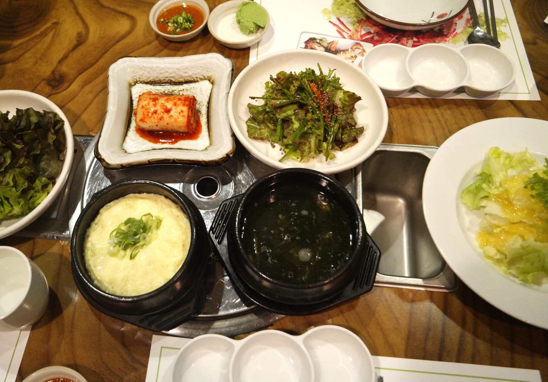 Meza kamili ya hoejip Korea, saladi, mboga, kimchi, gyeran-jjim na miyeok-guk zote zimewekwa | 하이제이에스비