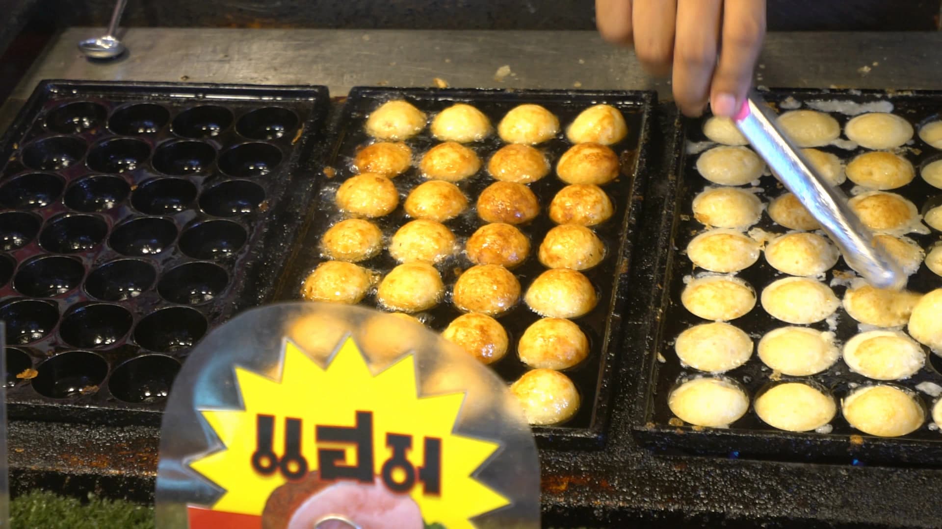 태국 시장 타코야키 굽는 모습 – 동그란 틀에서 하나씩 뒤집고 있는 장면