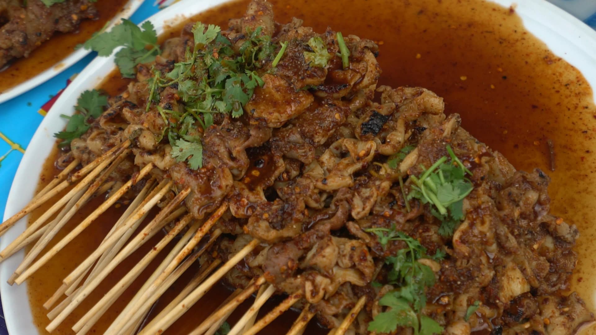 태국 시장 돼지 막창꼬치 – 진한 소스와 고수가 올려진 구운 막창꼬치