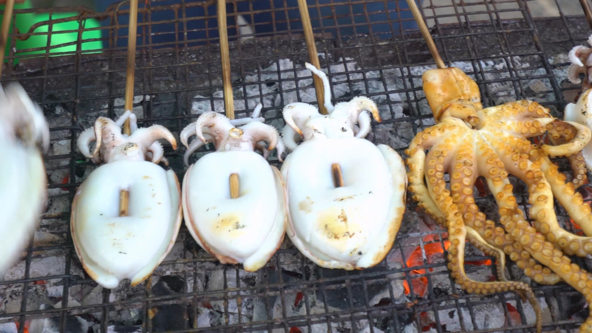 태국 시장 해산물 꼬치 – 숯불 위에서 오징어와 문어를 통째로 굽는 모습