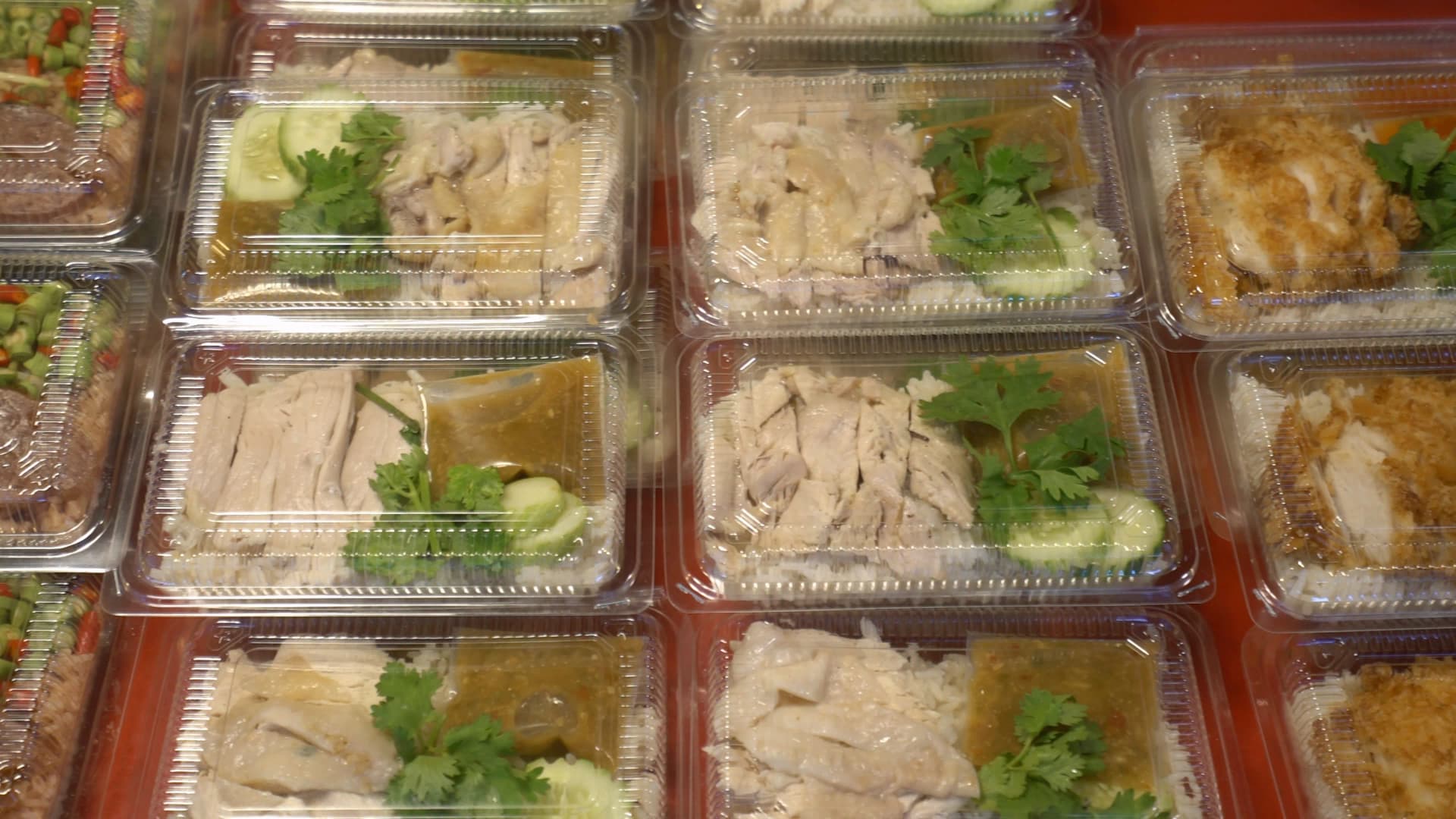 태국 시장 카오만까이 도시락 – 투명 용기에 닭고기와 밥이 담긴 포장 간편식