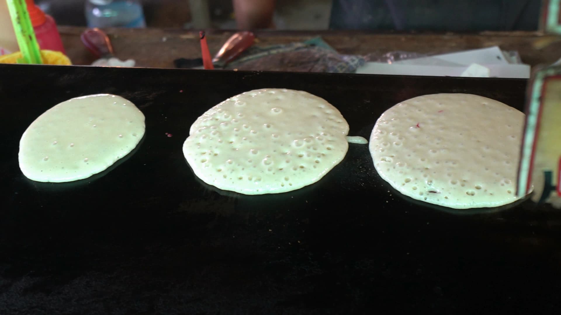 태국 시장 팬케이크 – 뒤집은 팬케이크 위에 빨간 소스로 그림 그리는 모습