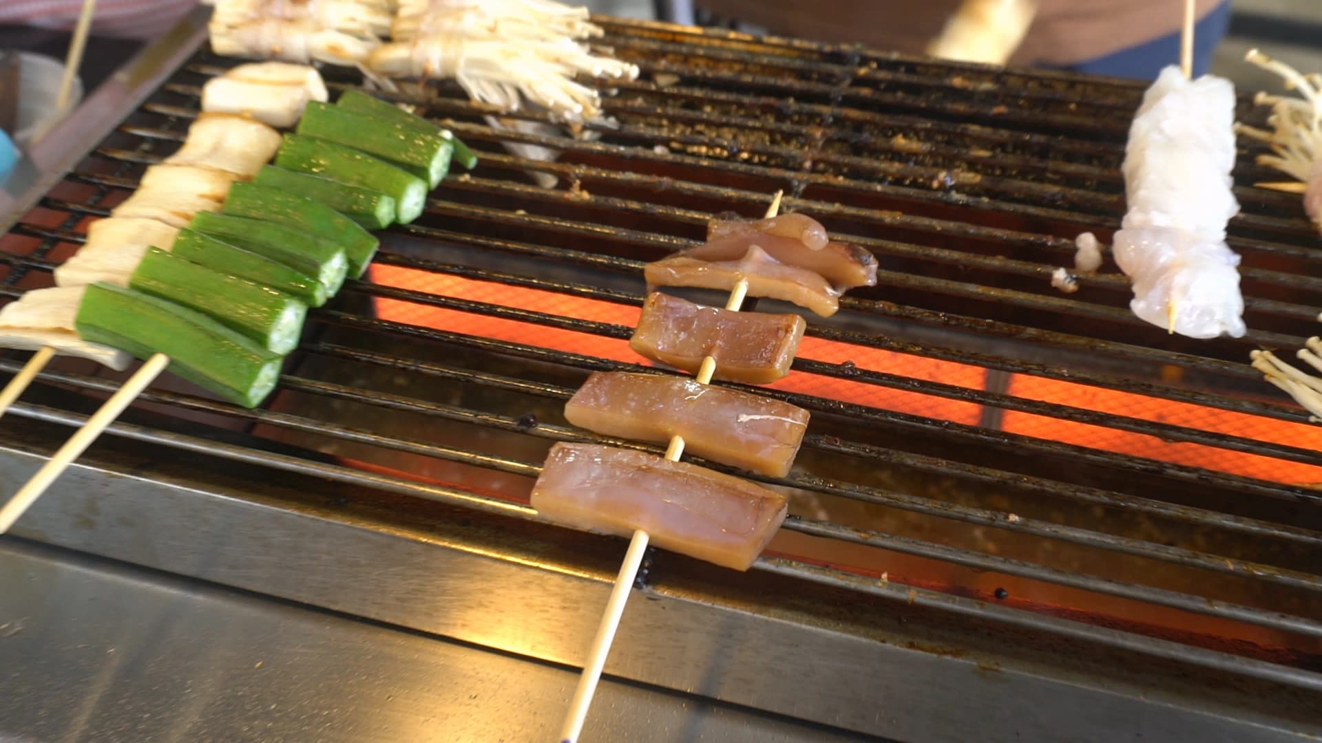 태국 시장 돼지껍데기 꼬치 – 꼬치에 꿴 돼지껍데기를 숯불에 굽는 모습