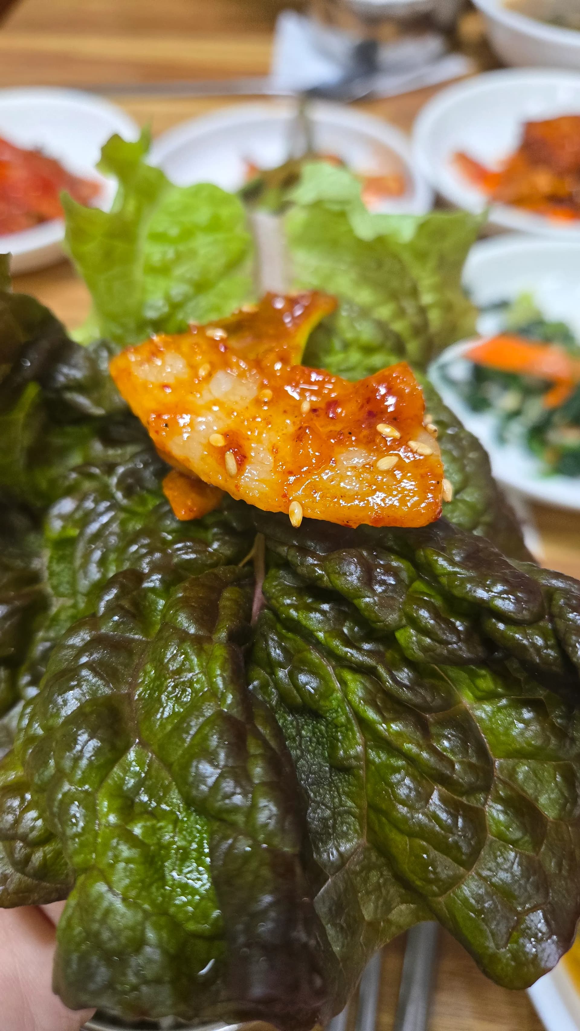 제육볶음 쌈 싸먹기 - 상추 위에 제육볶음과 파김치를 올려 싸먹는 모습 | 하이제이에스비