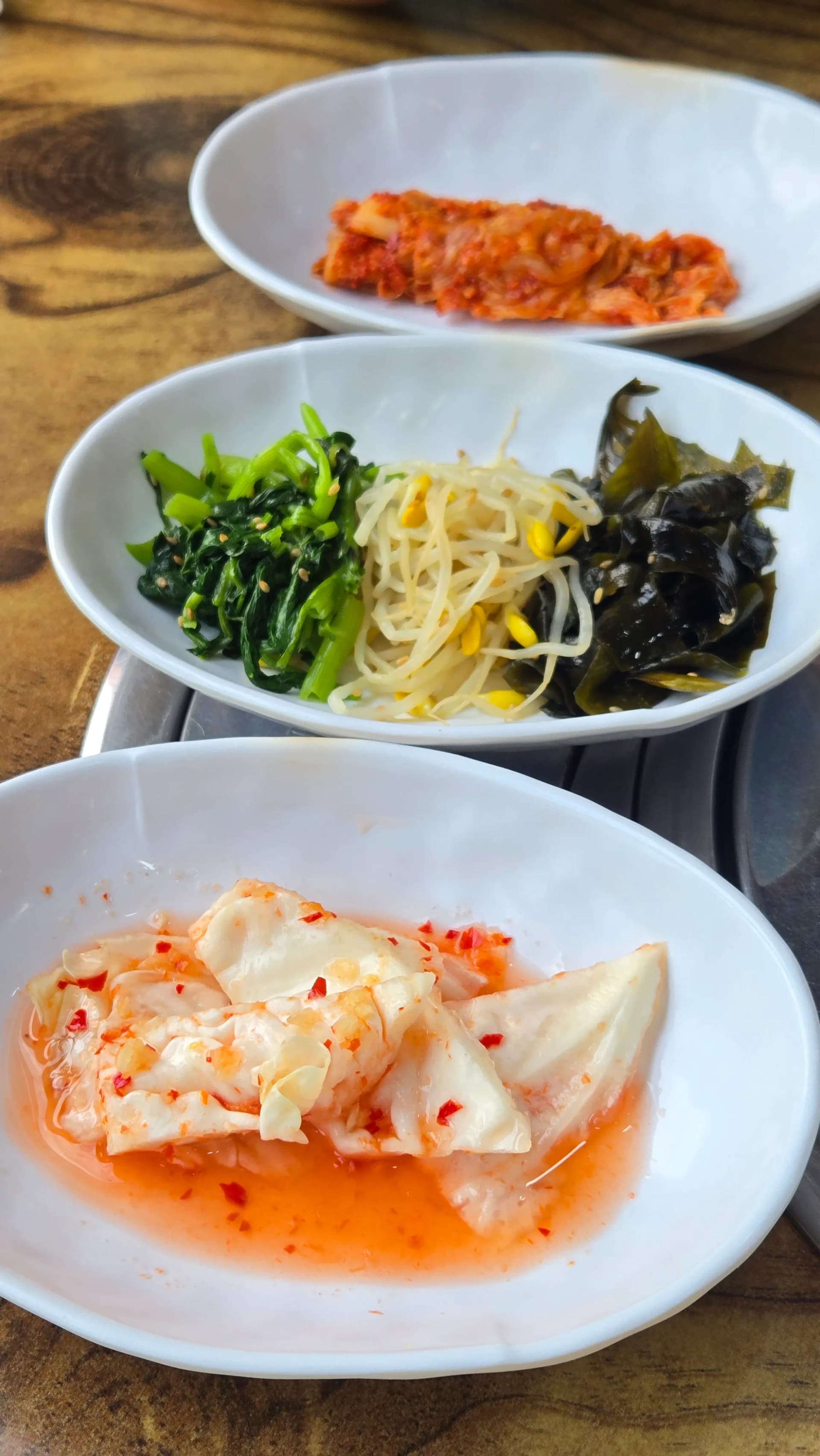 한 접시에 김치, 시금치나물, 콩나물, 미역, 양배추가 담긴 백반 반찬 모음 | 하이제이에스비