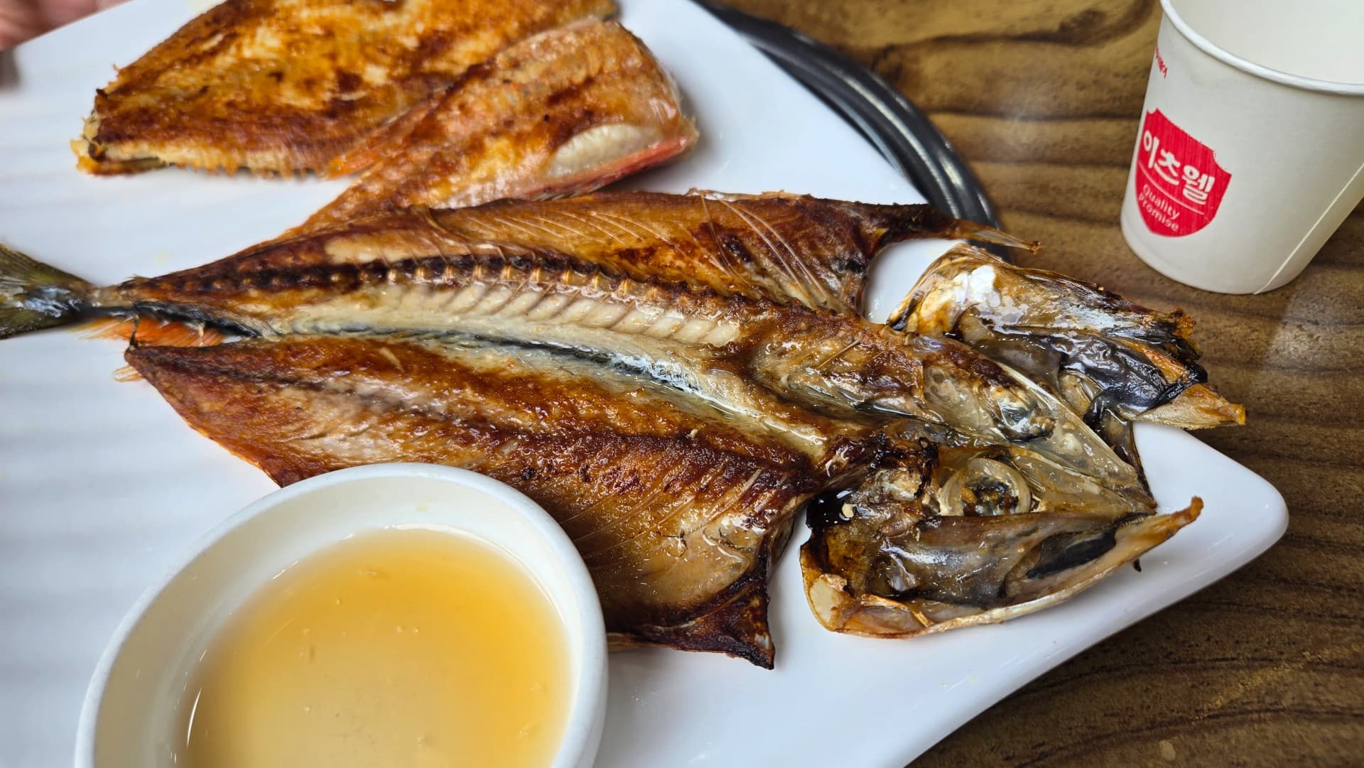 생선구이 백반의 메인, 접시에 세 종류의 구운 생선이 나란히 담겨 있고 옆에 초장이 놓여 있다 | 하이제이에스비
