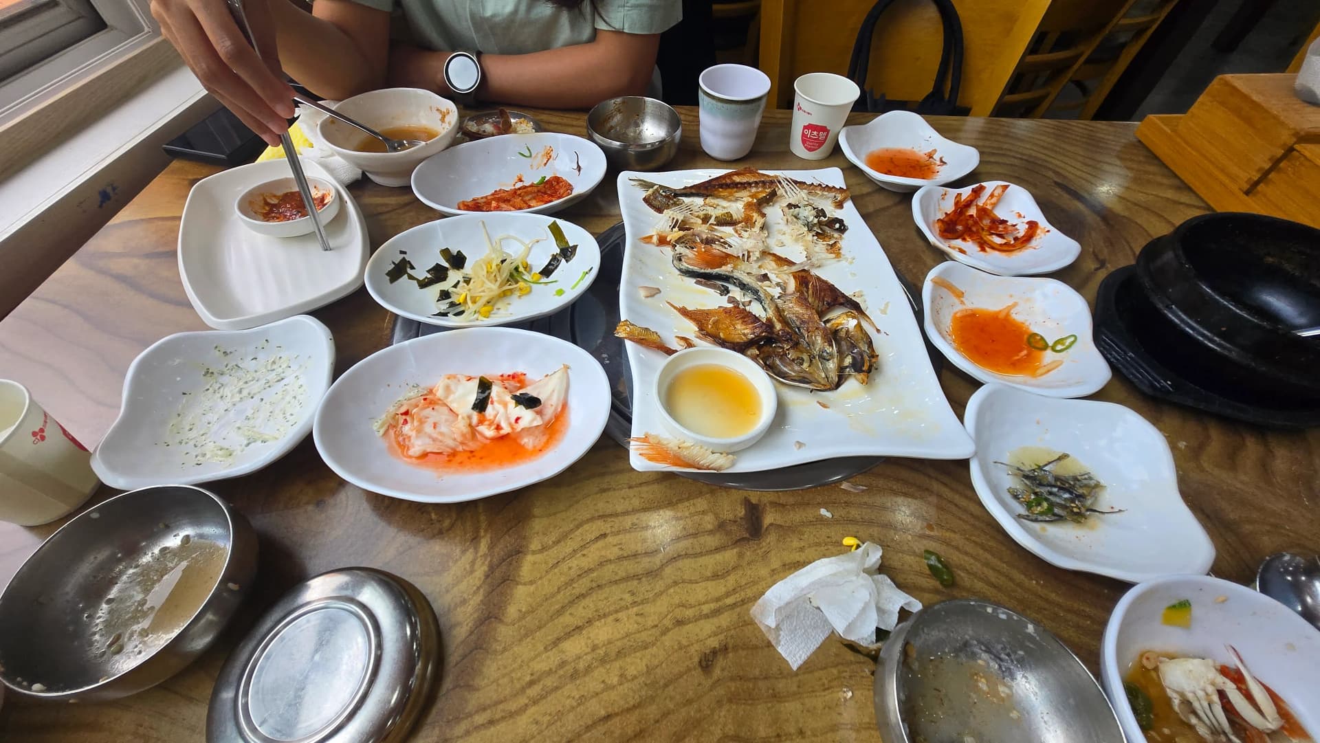 다 먹은 뒤의 백반 상, 생선은 뼈만 남고 반찬 접시와 찌개가 비어 있다 | 하이제이에스비