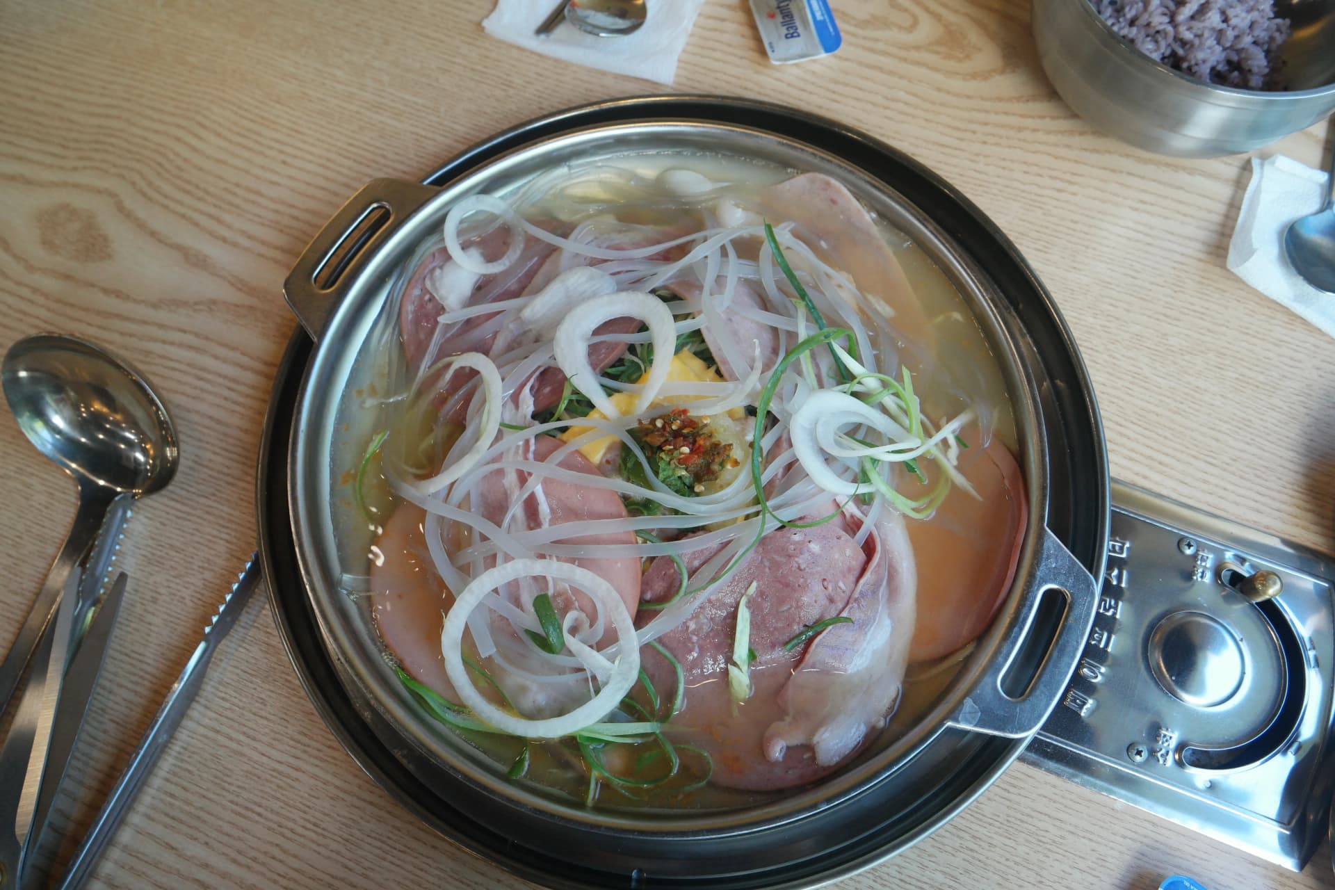 Budae-jjigae inayochemka sufurini na ham, soseji, vitunguu na vitunguu vya kijani | 하이제이에스비