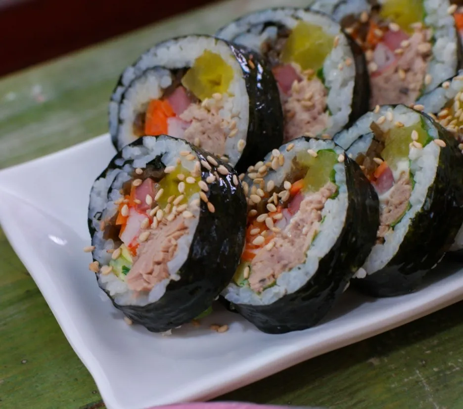 Tuna kimbap cross-section close-up showing layers of tuna carrot radish ham and spinach | 하이제이에스비