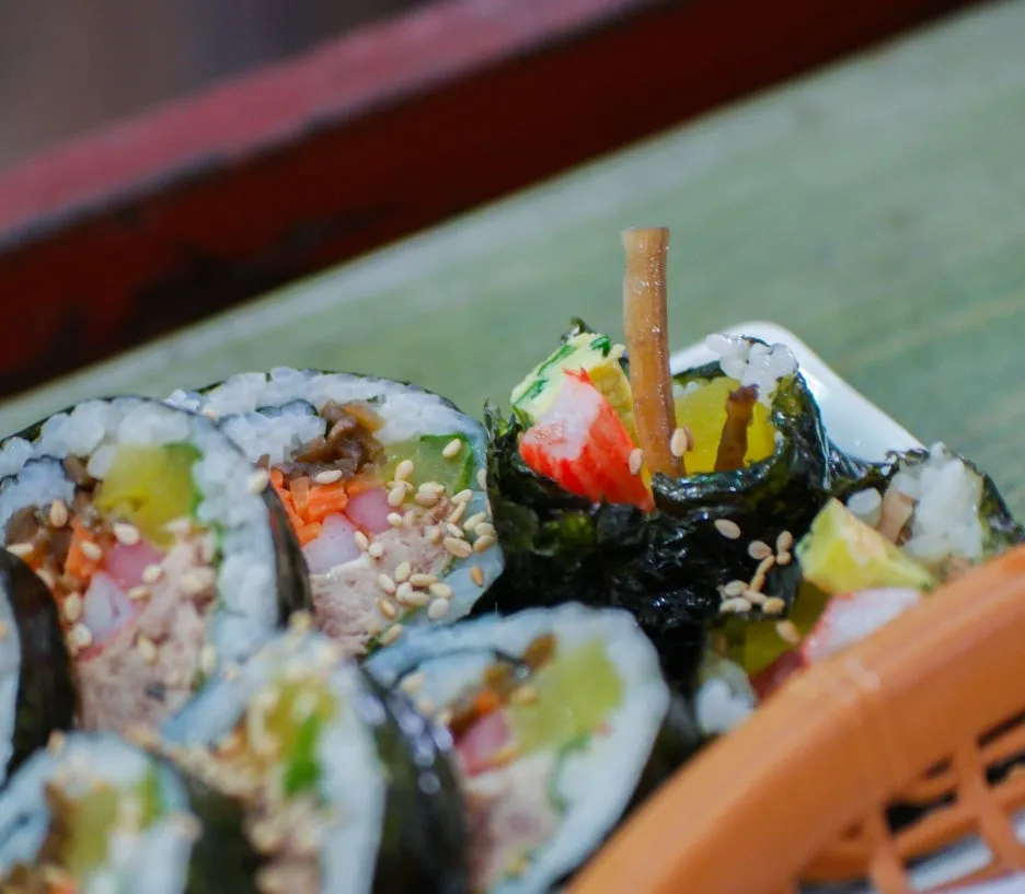 Kimbap cross-section with burdock root sticking up from the top at a bunsik shop | 하이제이에스비
