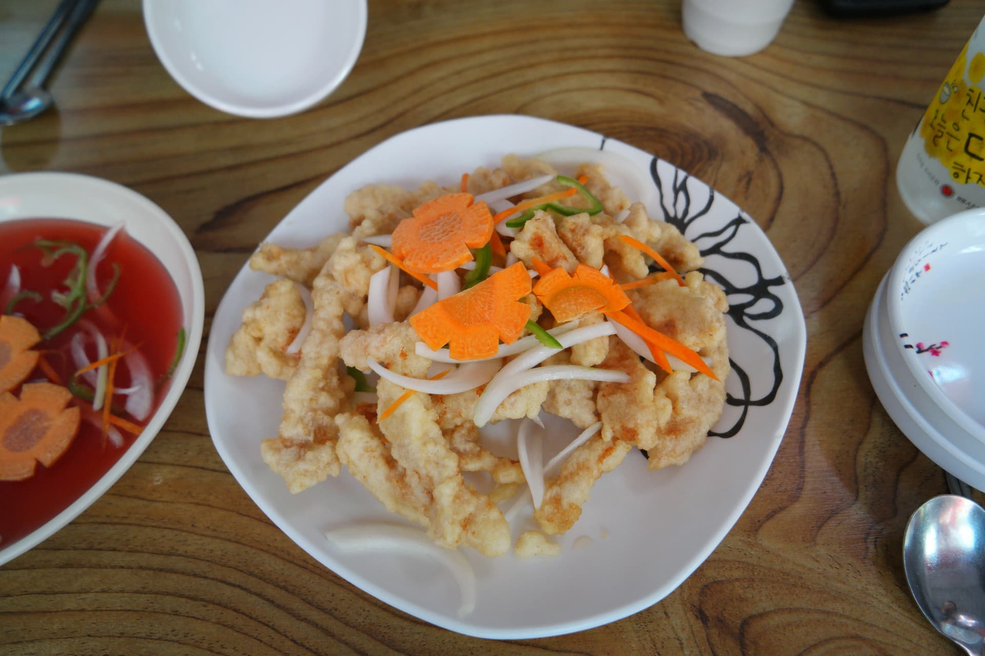 바삭하게 튀긴 탕수육 위에 당근 오이 양파가 올라가 있고 옆에 새콤달콤한 탕수 소스가 따로 담긴 접시 | 하이제이에스비