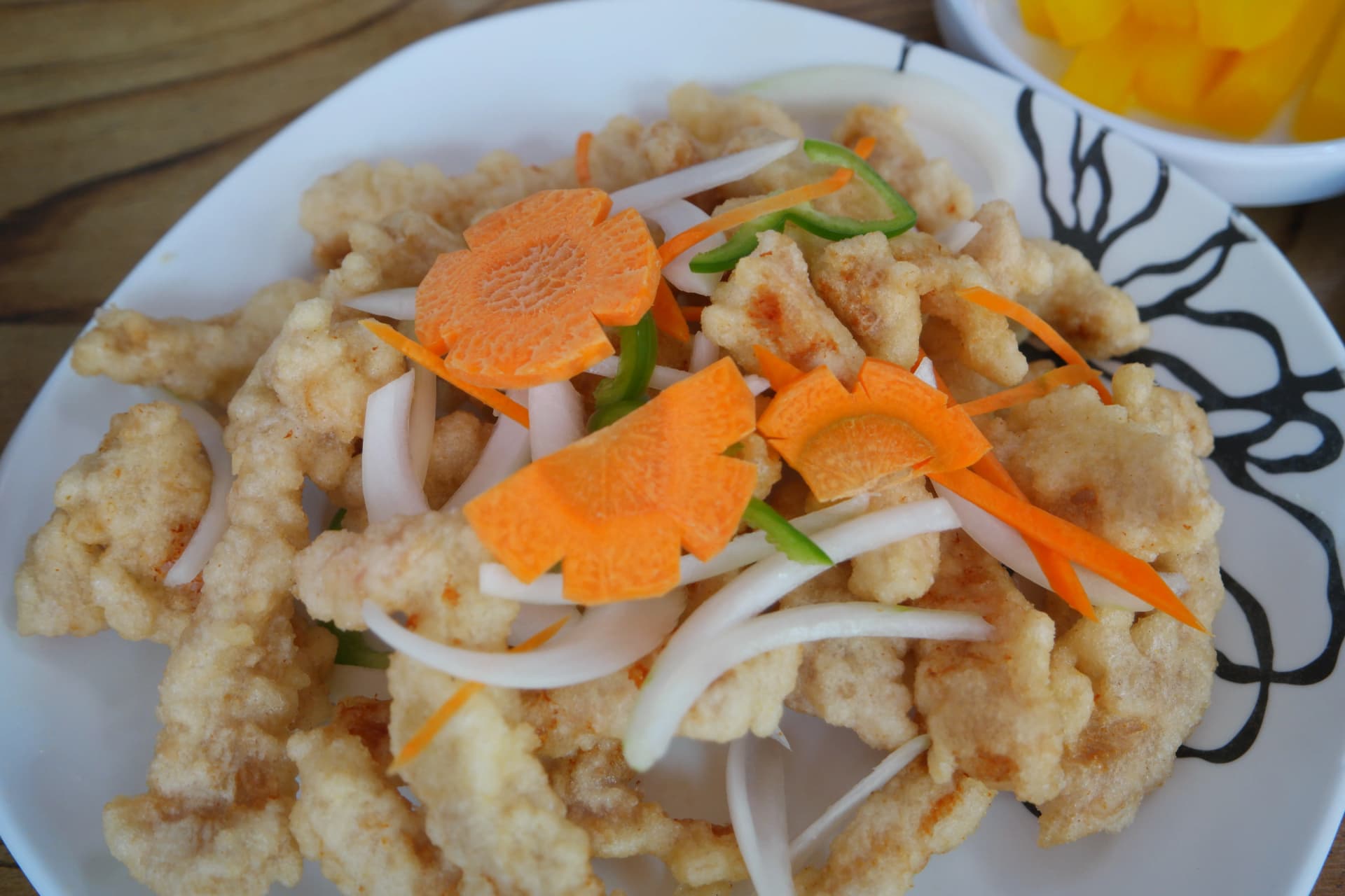 탕수육 전체 모습, 두툼한 튀김옷의 돼지고기가 접시에 쌓여 있고 꽃 모양 당근과 채 썬 양파 청피망이 올라간 소스 붓기 전 상태 | 하이제이에스비