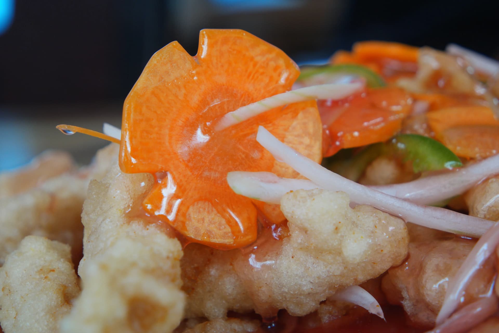 꽃 모양으로 조각된 당근 위로 탕수 소스가 흘러내리는 클로즈업, 중화요리 플레이팅 디테일 | 하이제이에스비