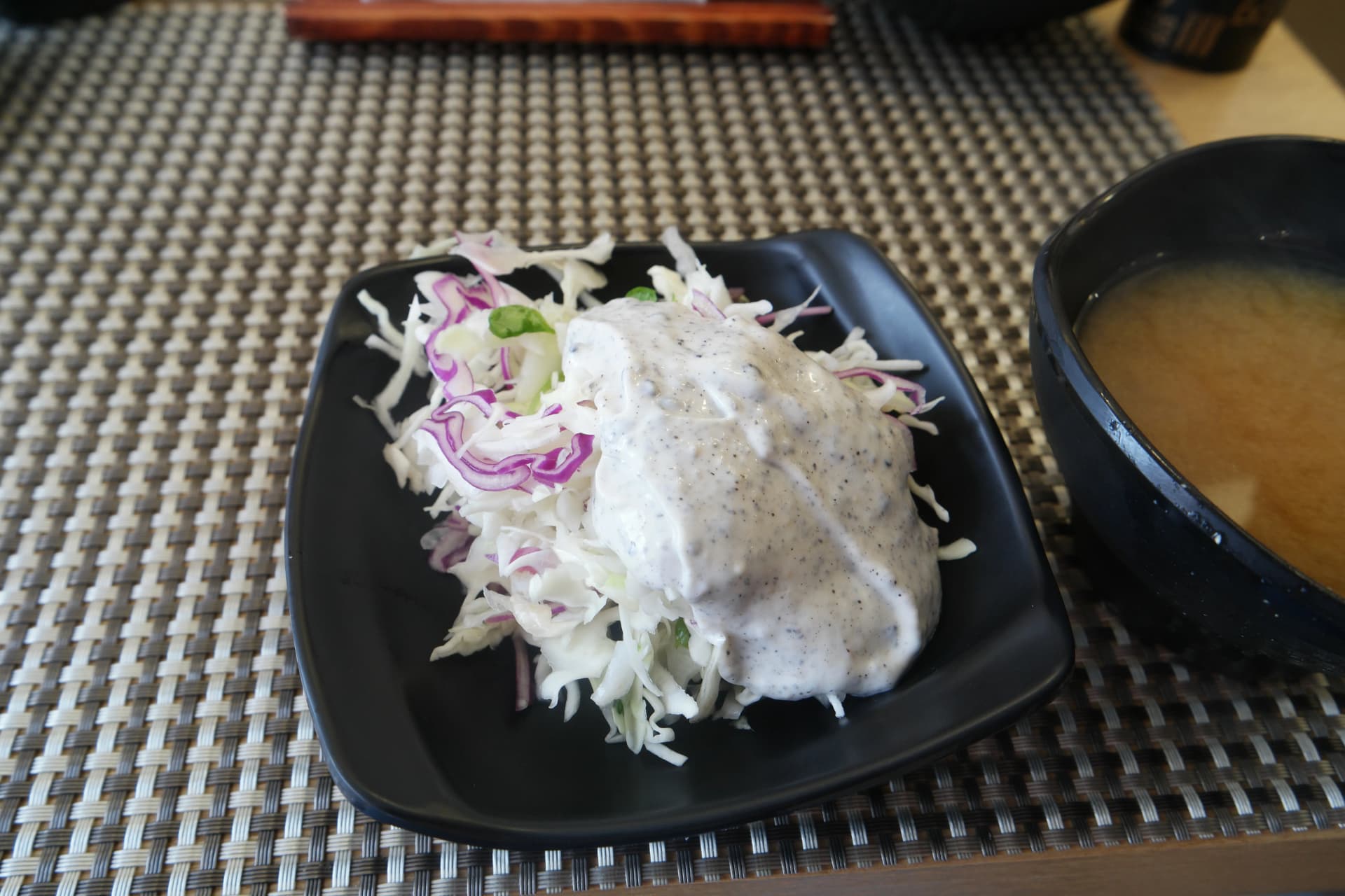 한국 초밥집에서 초밥 전에 제공되는 크리미한 드레싱이 올라간 양배추 샐러드 | 하이제이에스비