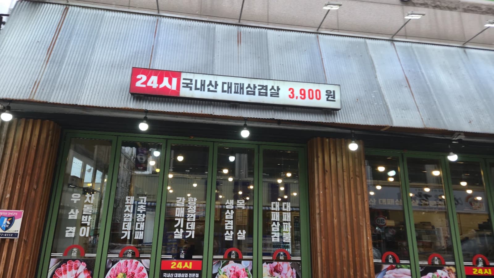 Letrero de local vecino de daepae samgyeopsal 24 horas a 3.900 wones la porción
