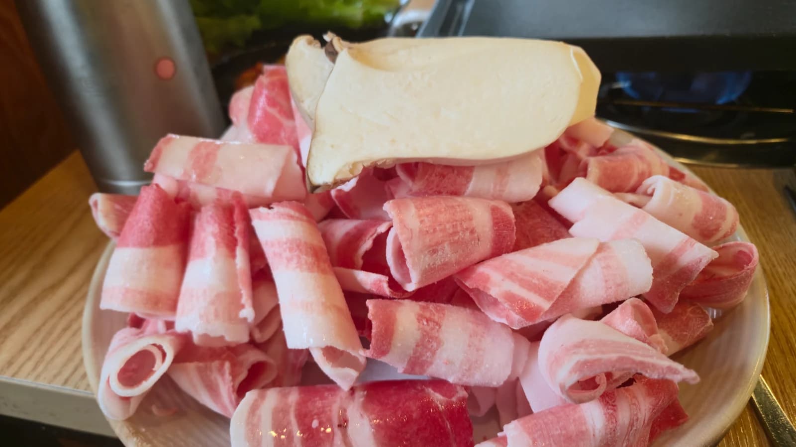 Láminas finas de daepae samgyeopsal con setas de ostra rey