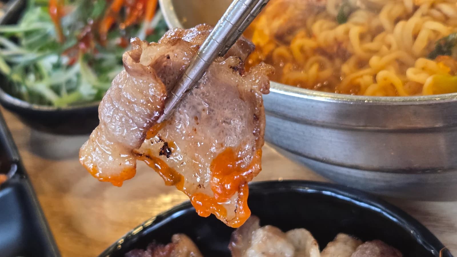 Trozo de daepae samgyeopsal mojado en salsa picante yangnyeom