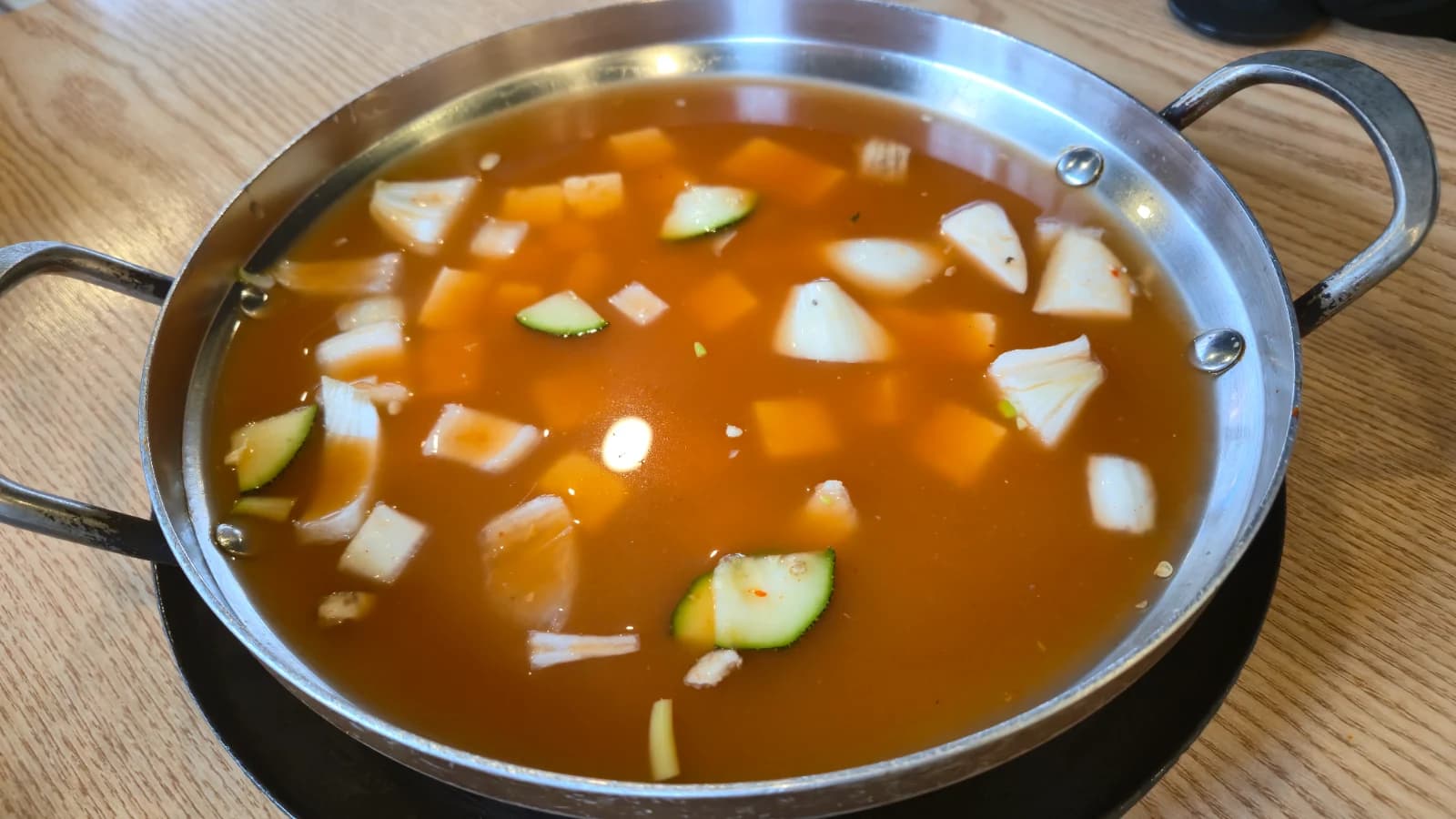 Sopa de doenjang recién servida con caldo claro y verduras flotando