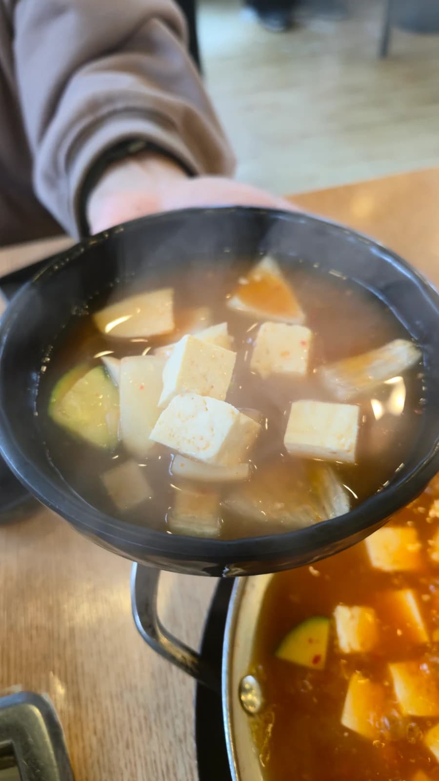 Primer plano del contenido de la sopa de doenjang con tofu, zapallo y cebolla