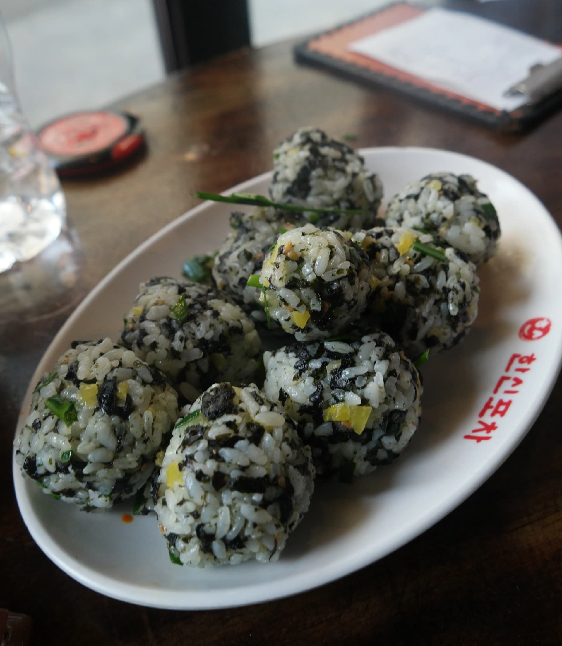 Varias bolitas de jumokbap ya terminadas, redondas y de un bocado, servidas en un plato