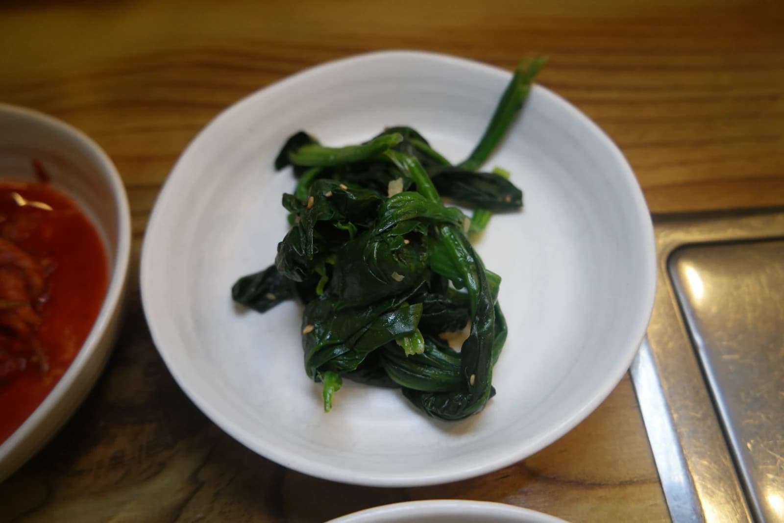 Sigeumchi-namul, blanched spinach seasoned with sesame oil and topped with sesame seeds
