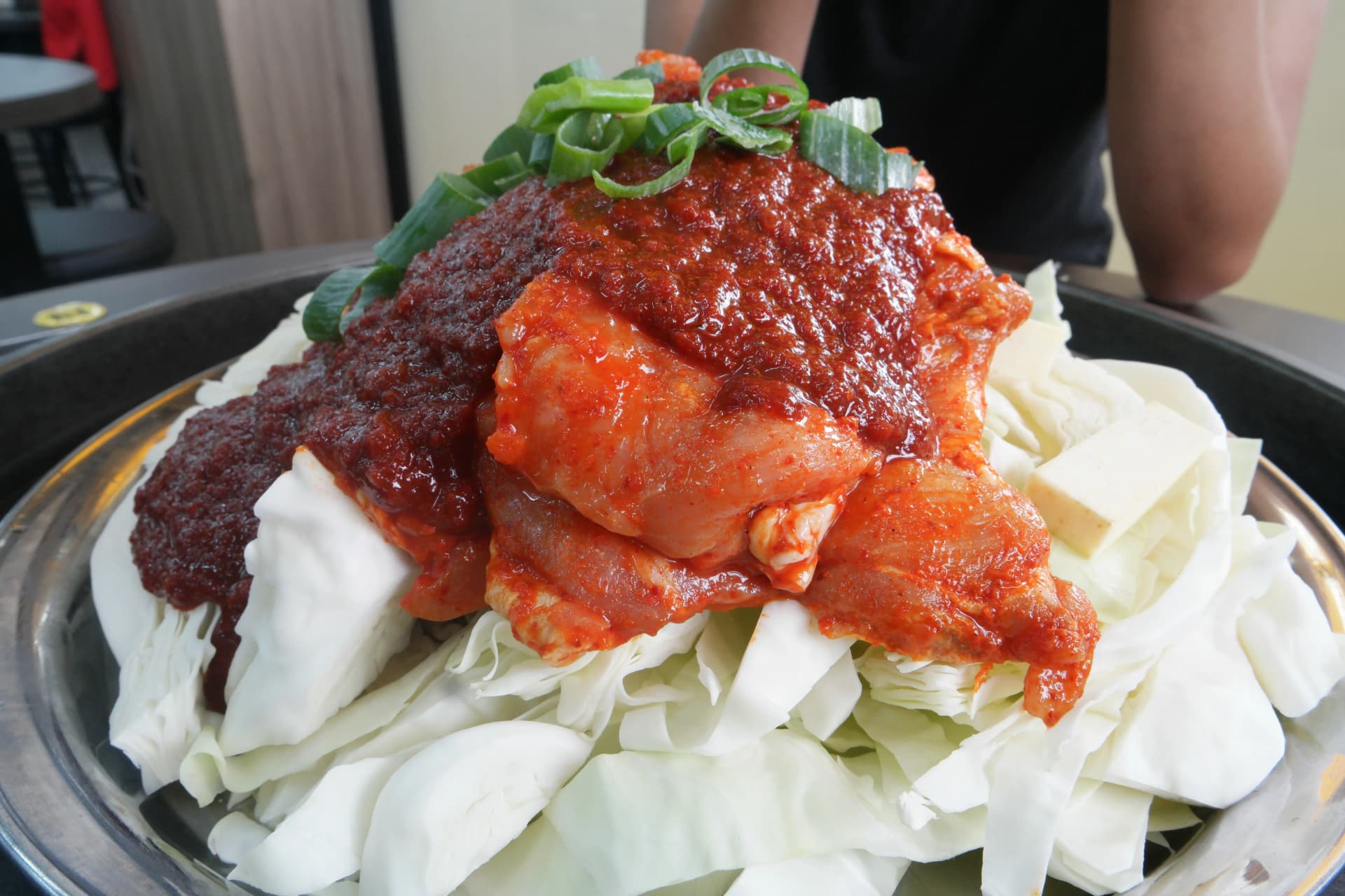 Picha ya karibu ya dakgalbi: mchanganyiko mzito wa gochujang juu ya kuku, kabla ya kukaangwa | 하이제이에스비