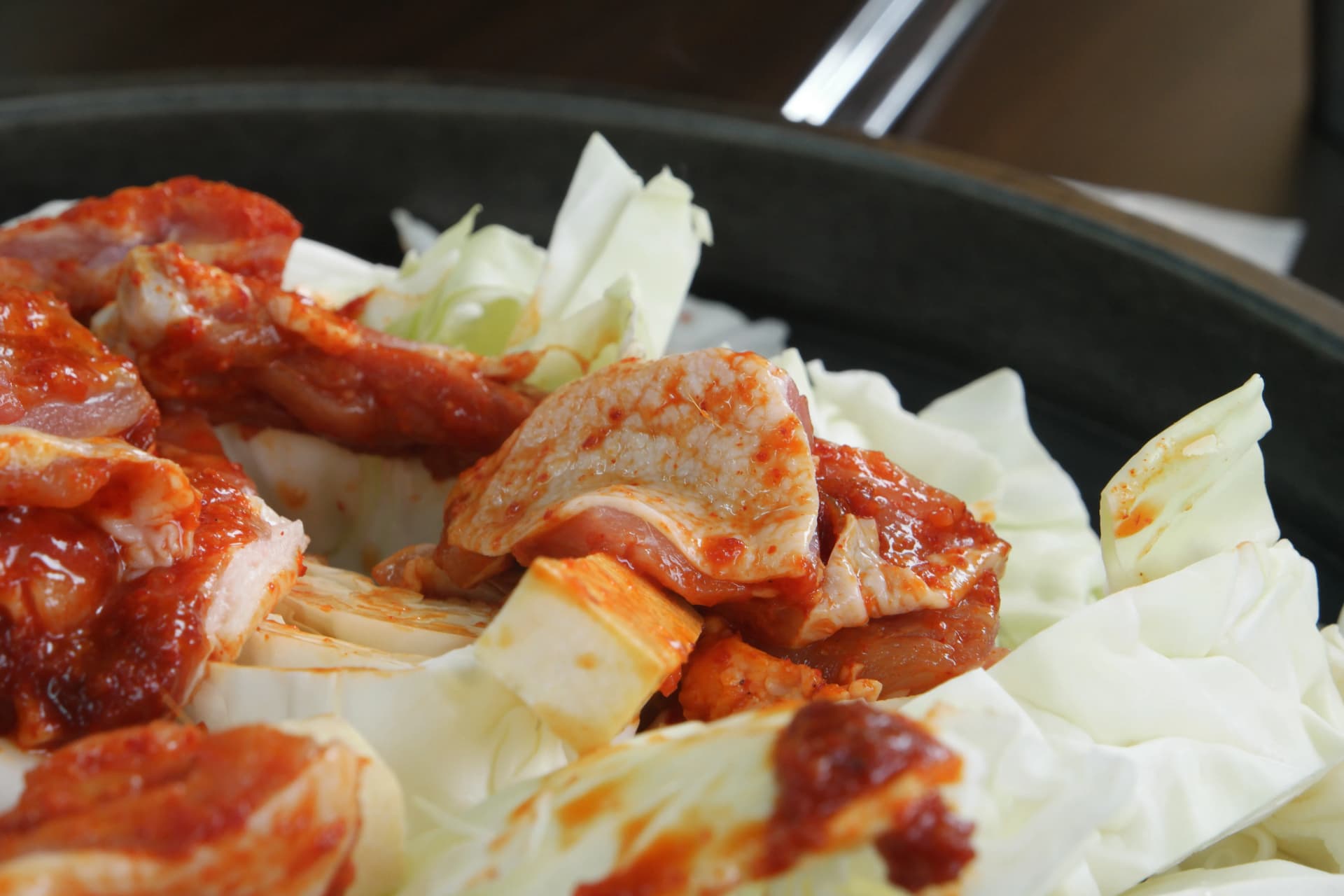 Hatua ya maandalizi ya dakgalbi: kabichi imesambazwa pembezoni mwa sahani ya chuma kabla ya kukaanga | 하이제이에스비