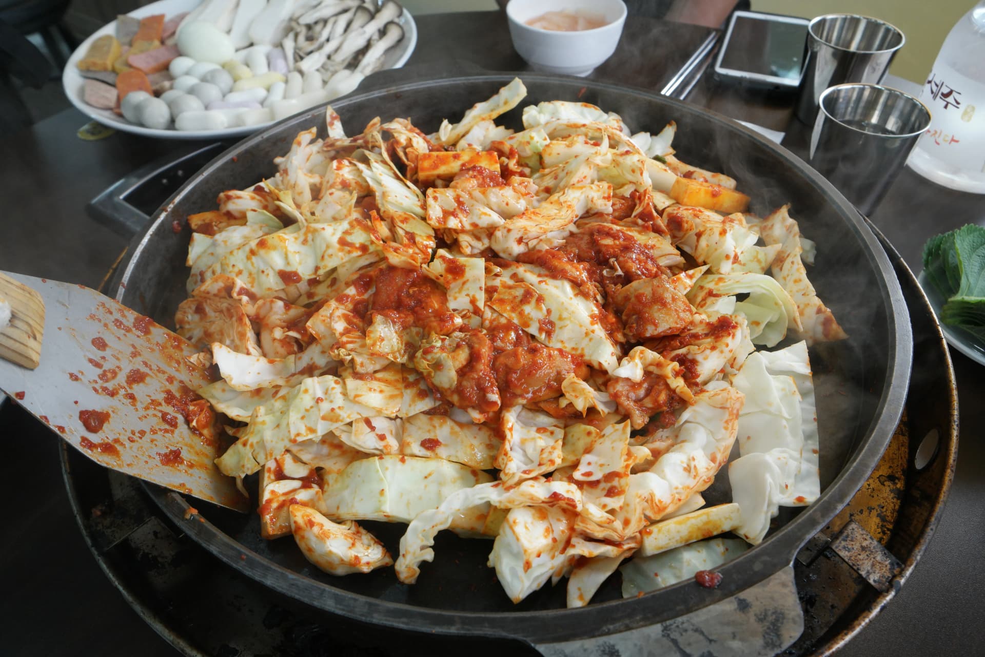 Dakgalbi juu ya sahani ya chuma wakati moto unapowashwa: kabichi na mchanganyiko wa viungo unaanza kusambaa | 하이제이에스비