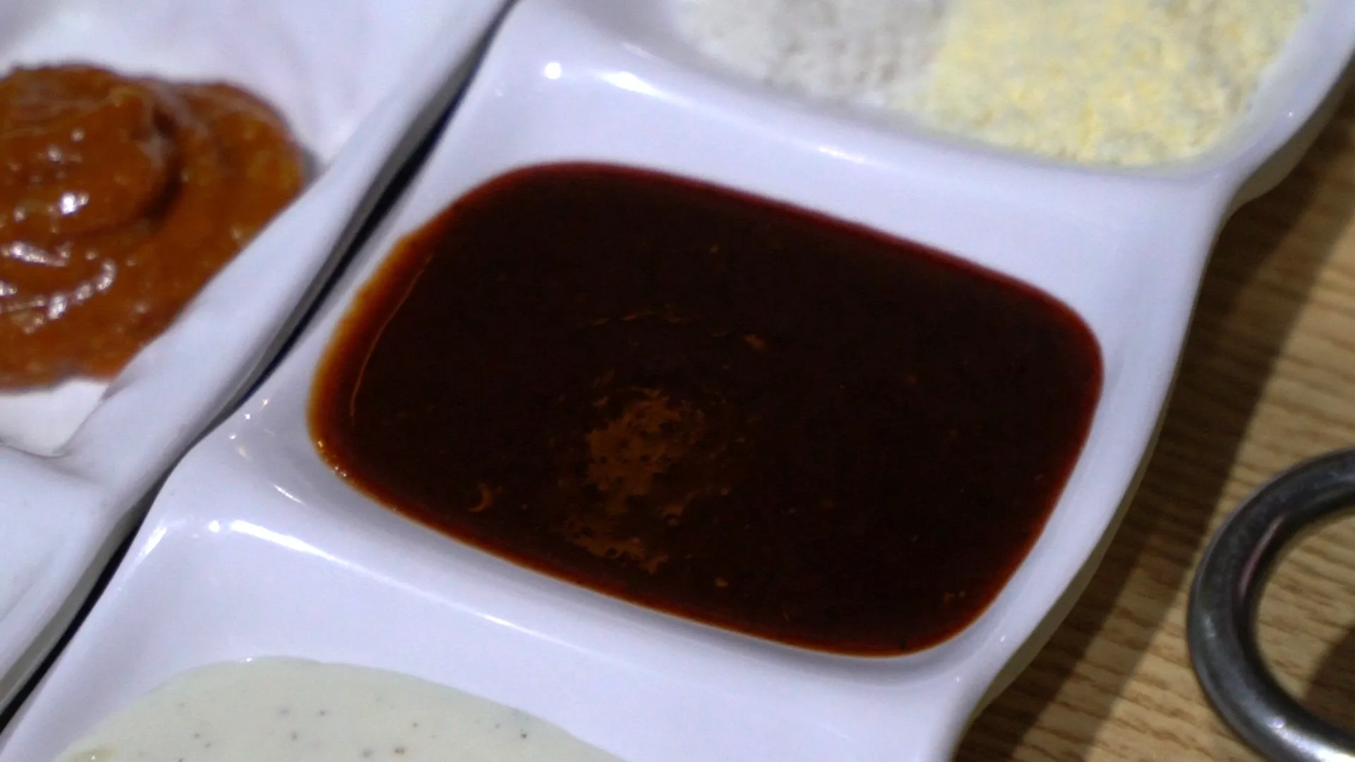 Ranch-style creamy dipping sauce with visible cracked pepper served alongside charcoal grilled dakgalbi