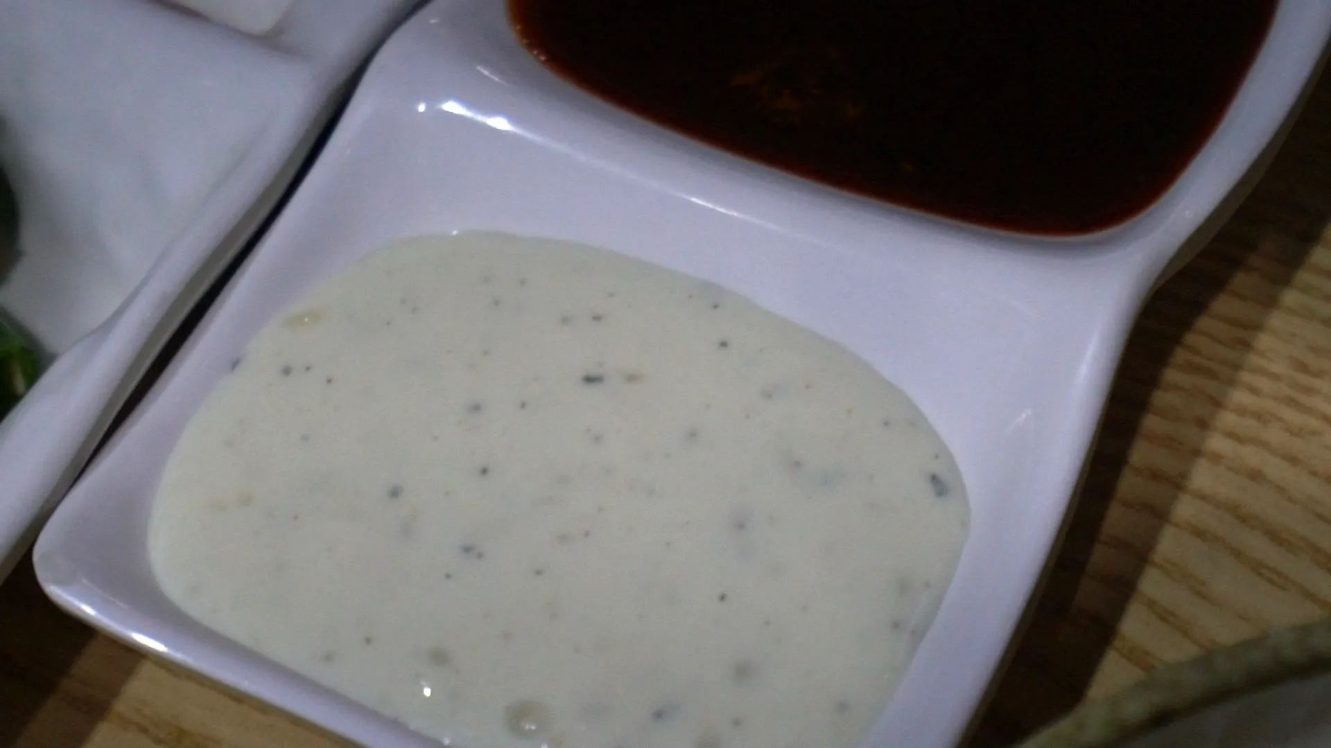 Sliced cheongyang green chilli peppers with seeds and ssamjang dipping sauce on a small plate