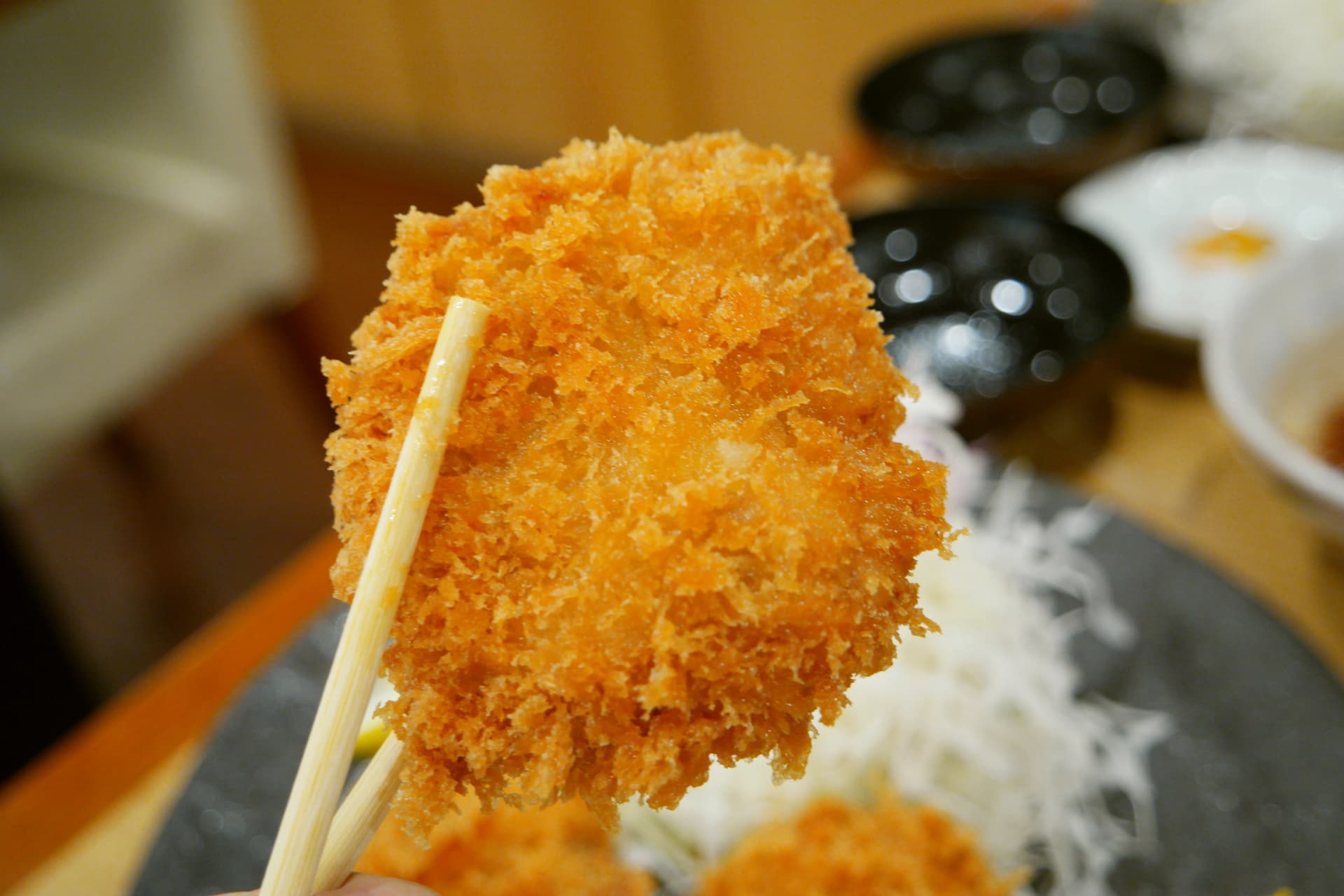 తయారైన నువ్వుల సాస్‌లో టోంకాట్సును ముంచి తినే దృశ్యం | 하이제이에스비