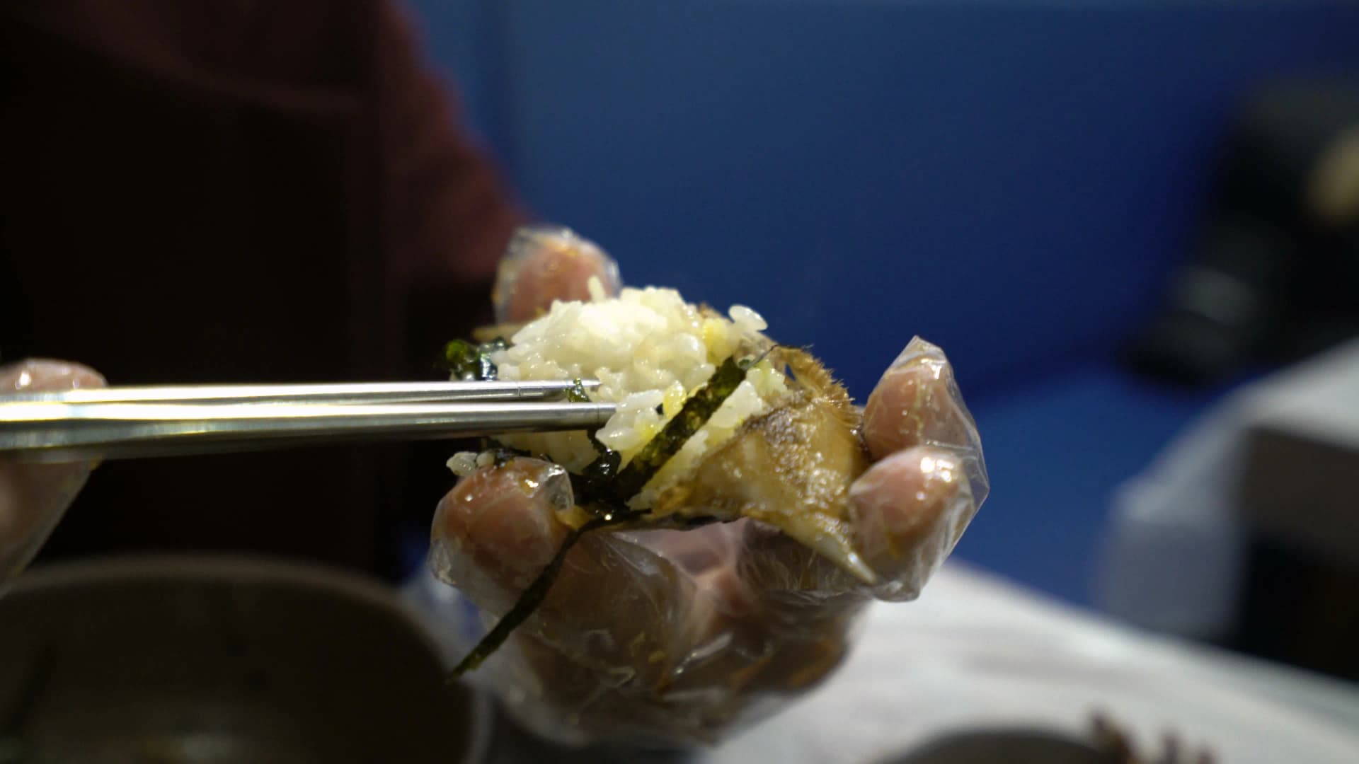 Yangnyeom gejang on a plate coated in thick red gochujang chilli sauce with sesame seeds and spring onions