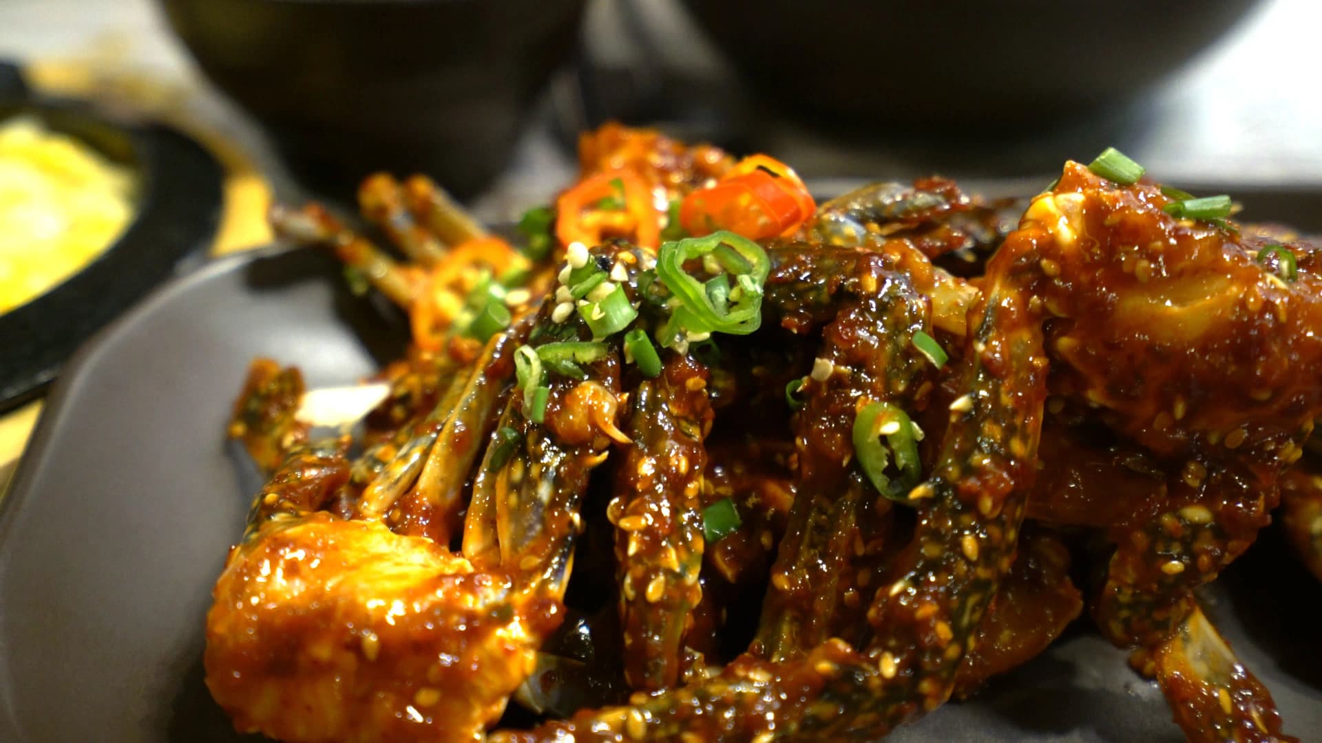 Close-up of yangnyeom gejang showing thick red chilli paste coating the crab shell surface