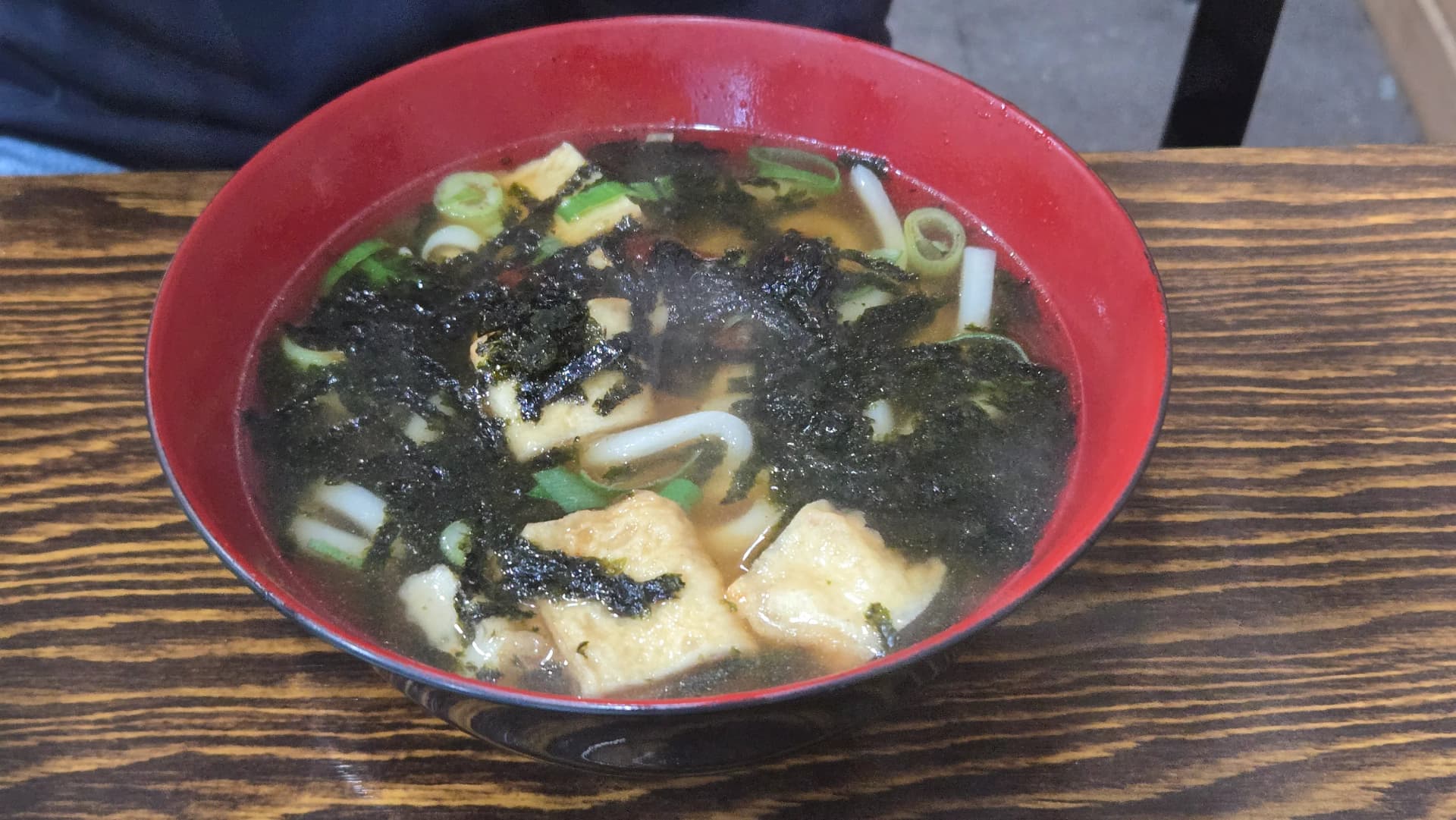 ಕೊರಿಯನ್ ನೂಡಲ್ ಸೂಪ್ ಕ್ಲೋಸ್‌ಅಪ್ – ಗಾಢ ಸಾರಿನ ಮೇಲೆ ಸಮುದ್ರ ಕಳೆ ಹುಡಿ ಮತ್ತು ಮೀನಿನ ಕೇಕ್ | 하이제이에스비