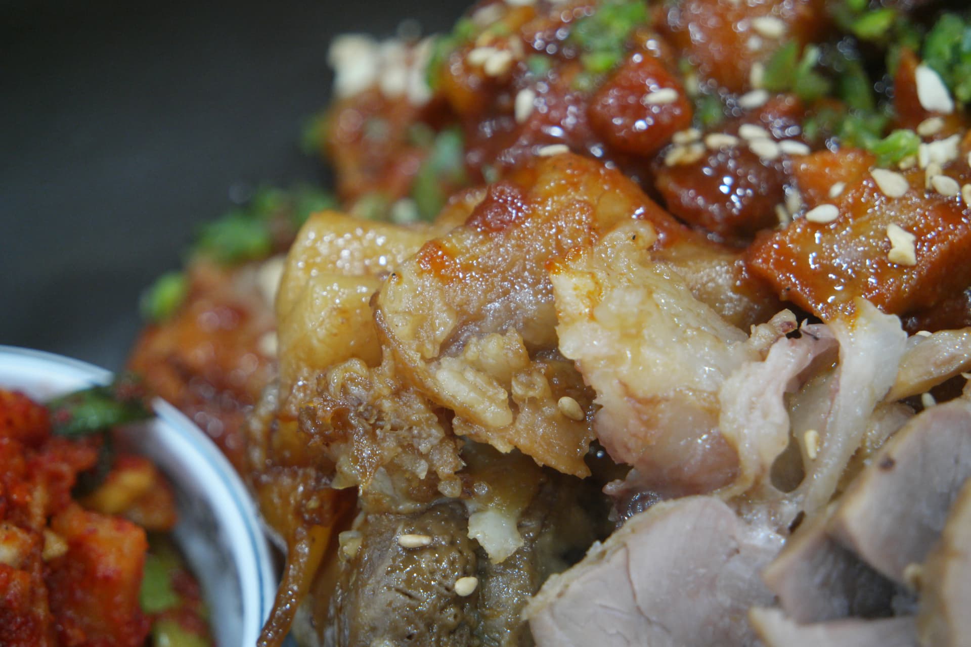 Nærbillede af stærk jokbal — rød stærk sauce og gennemsigtig elastisk svær fra klassisk jokbal i samme tværsnit | 하이제이에스비