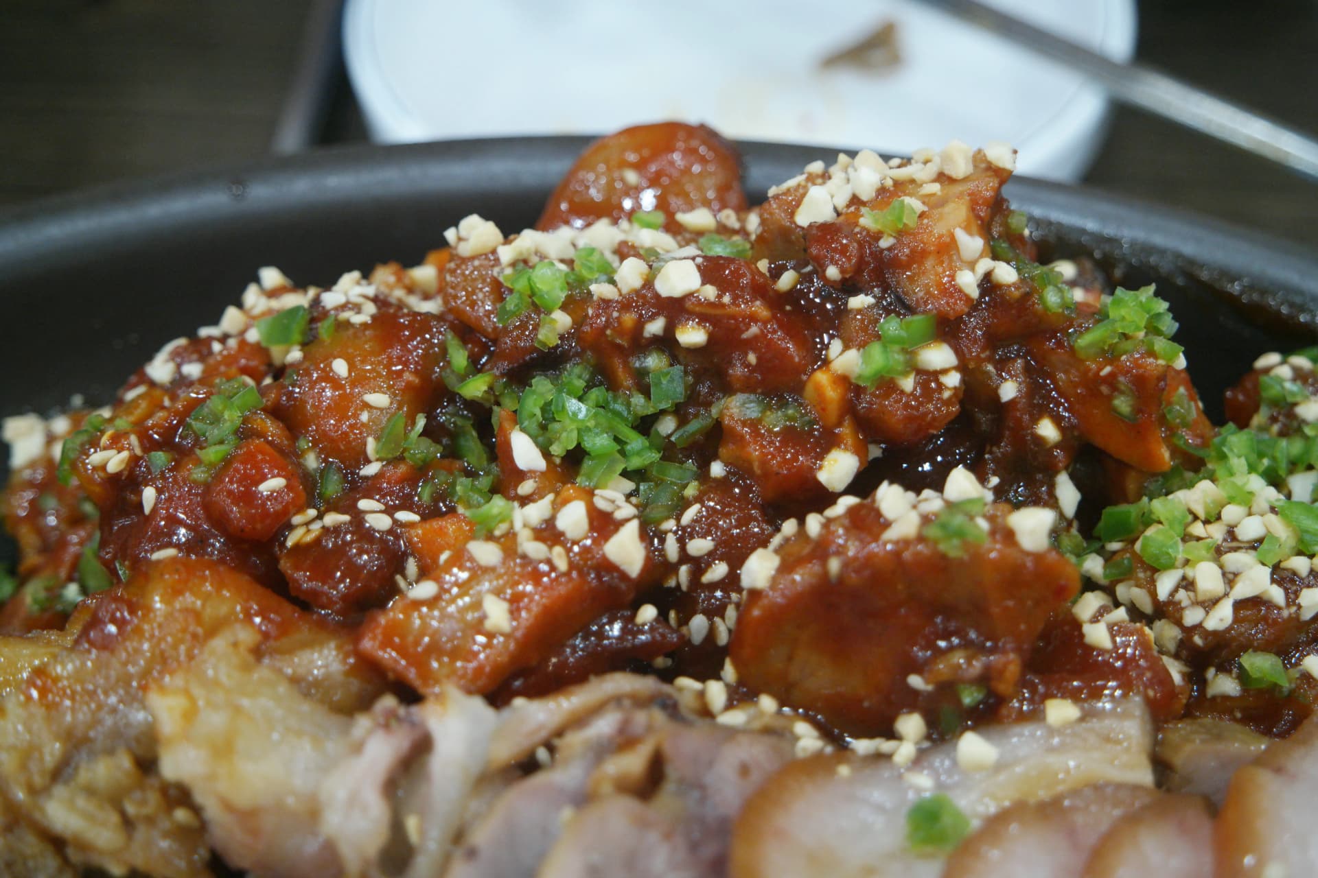 Nærbillede af stærk koreansk jokbal — gochujang-sauce tykt påført grisefødder | 하이제이에스비