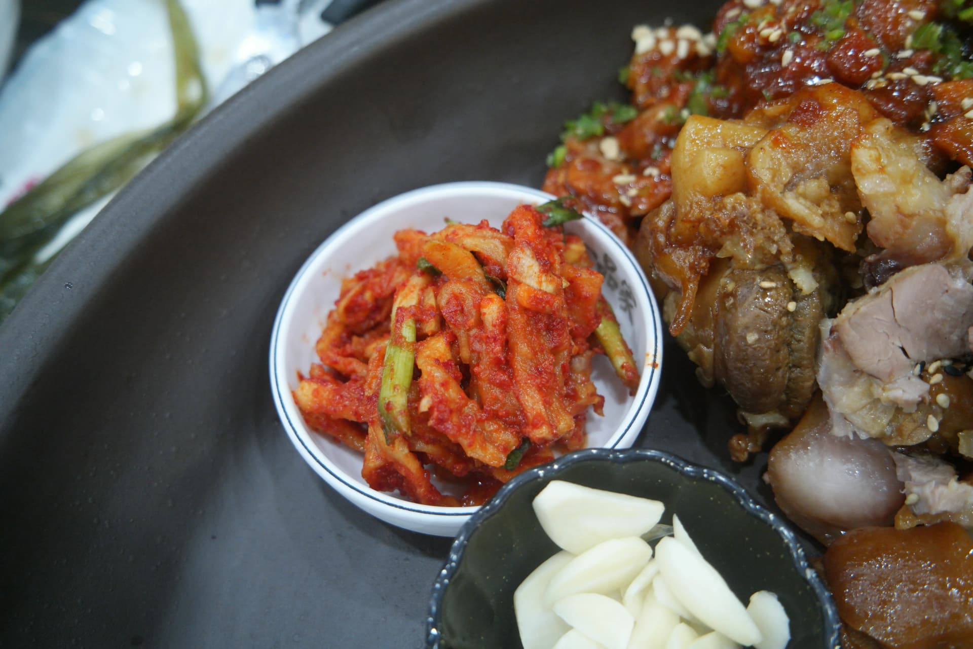 Kimchi og hvidløg som jokbal-tilbehør — moden kimchi og hele hvidløgsfed | 하이제이에스비