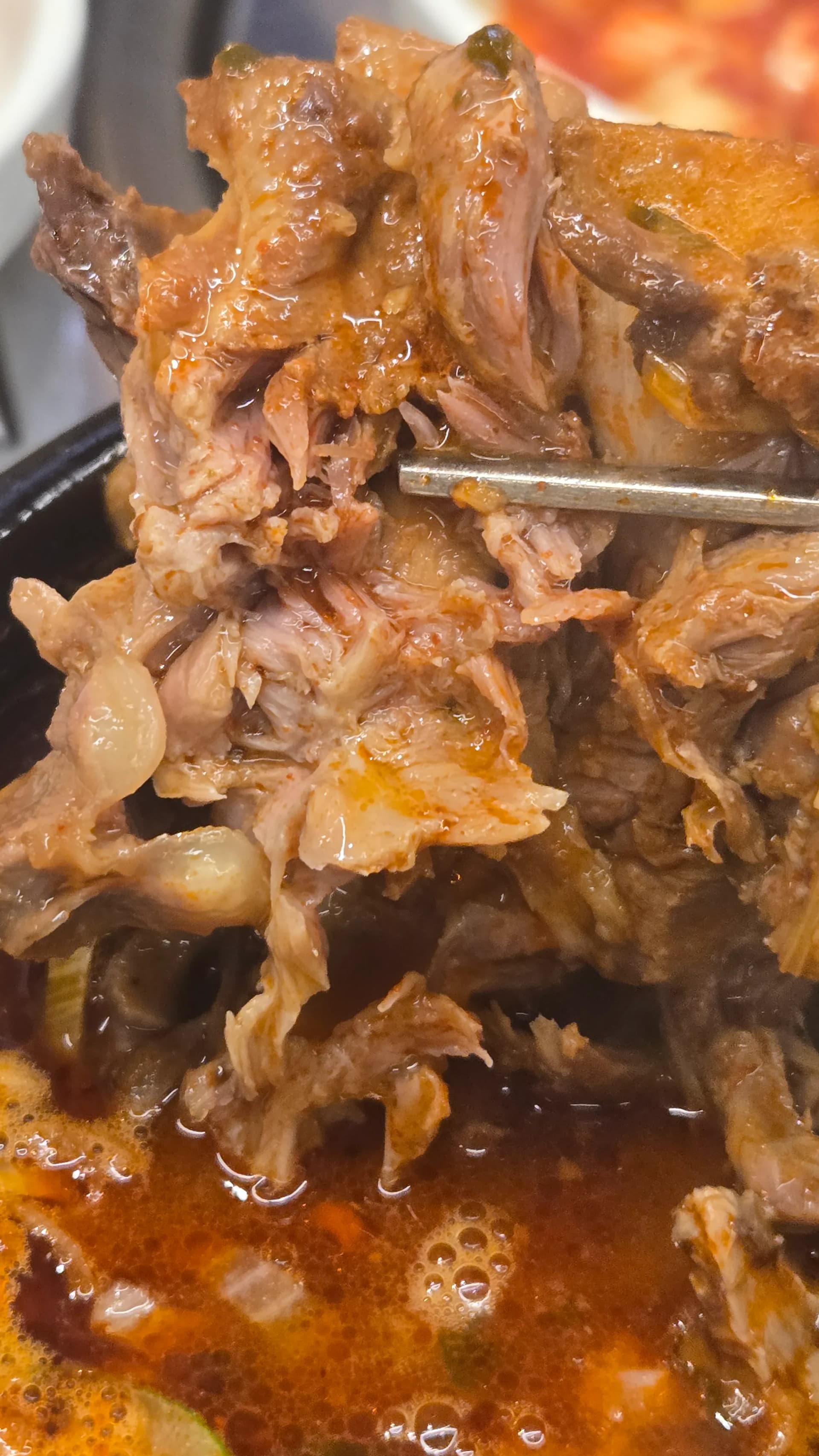 ຄລິບໃກ້ໆຂອງຊີ້ນໝູທີ່ຕິດຢູ່ກັບກະດູກໃນຊຸບກະດູກໝູ ມີຊີ້ນເຕັມຫຼາຍ | 하이제이에스비