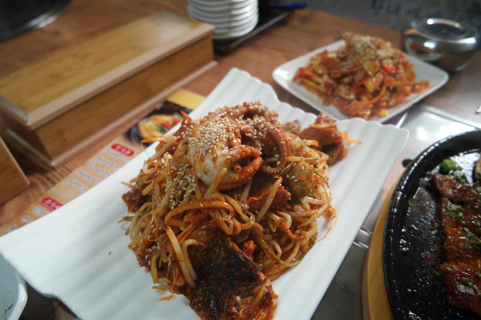 طبق هوانغتيه البحري الحار كاملًا — هوانغتيه وأخطبوط صغير وميدودوك فوق براعم الفاصوليا بصلصة حمراء حارة