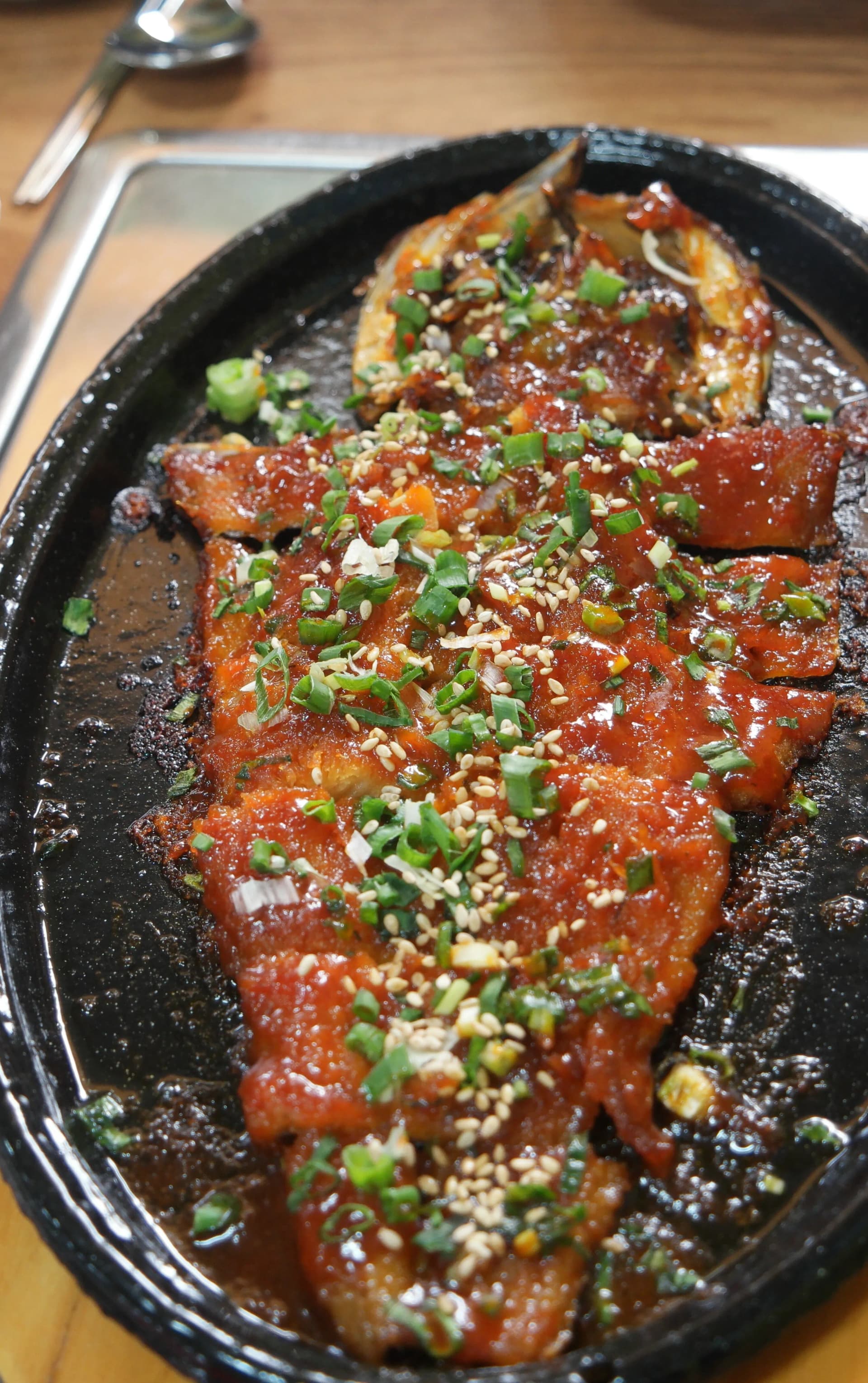 هوانغتيه جوريم — سمكة كاملة مطهوة بصلصة الغوتشوجانغ على صينية معدنية ساخنة