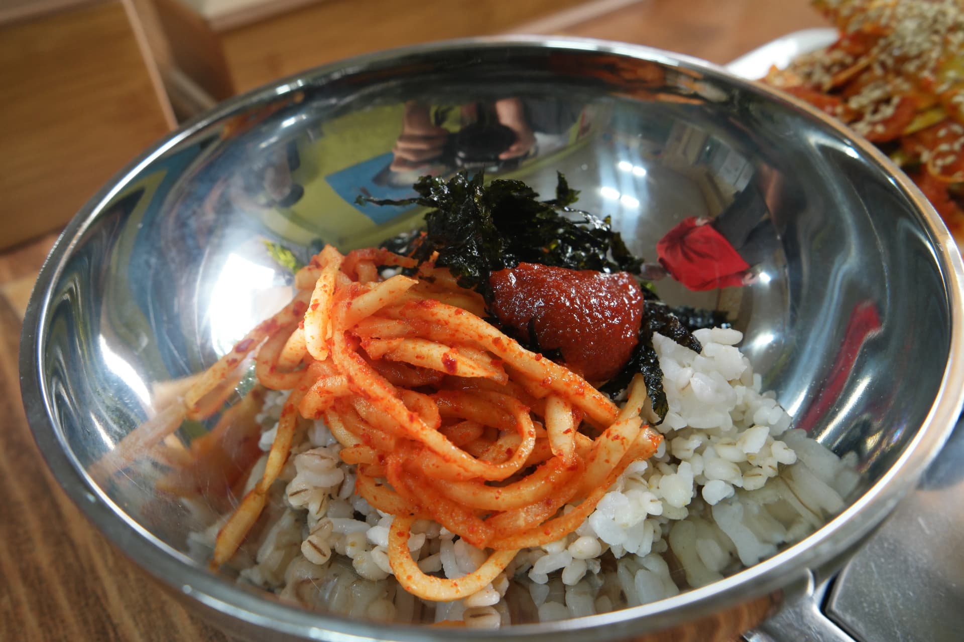 أرز شعير في وعاء معدني كبير مع مخلل الفجل ورقائق الأعشاب البحرية وغوتشوجانغ