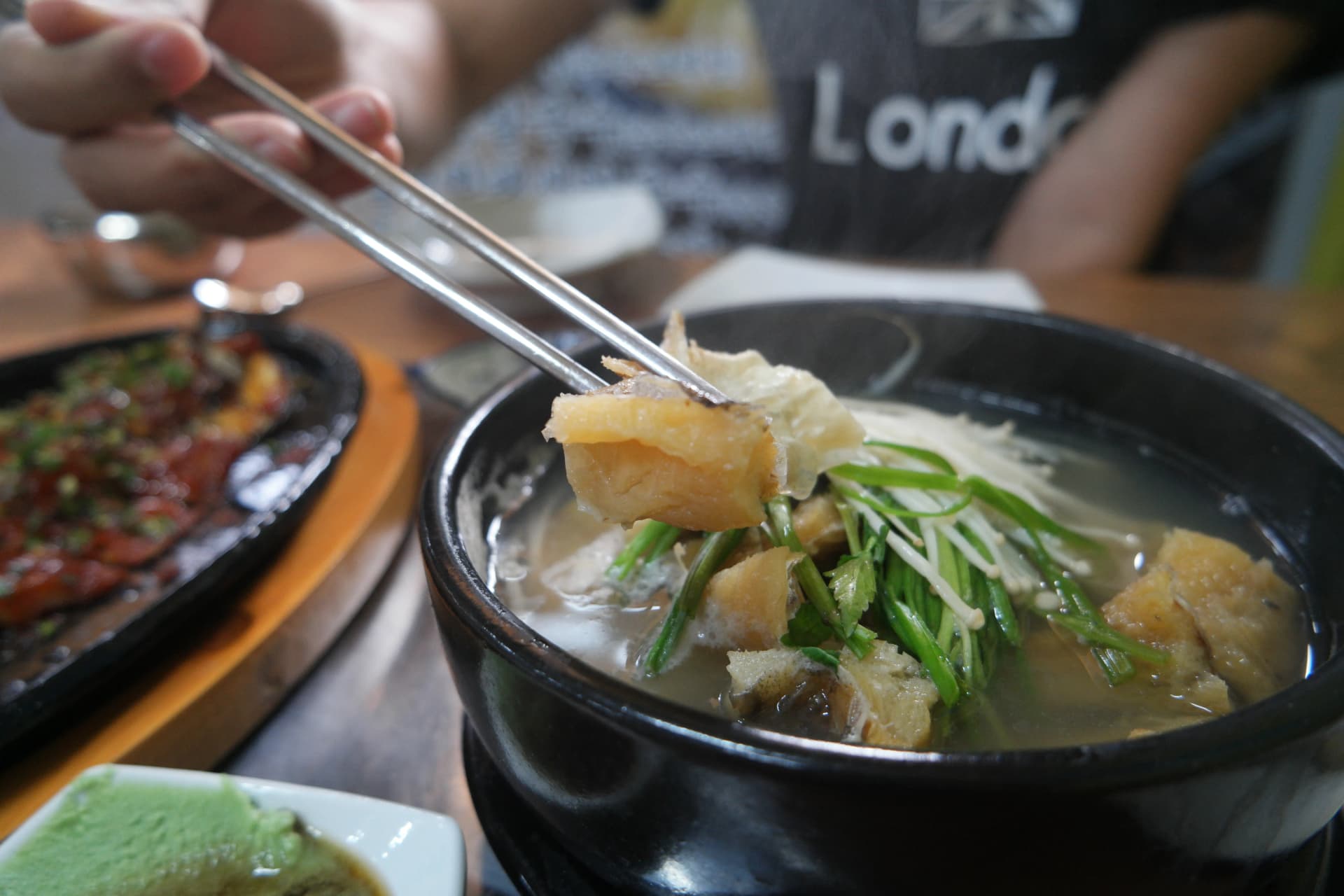 عيدان تلتقط قطعة هوانغتيه سميكة من الشوربة — سُمك لحم السمك المجفف واضح