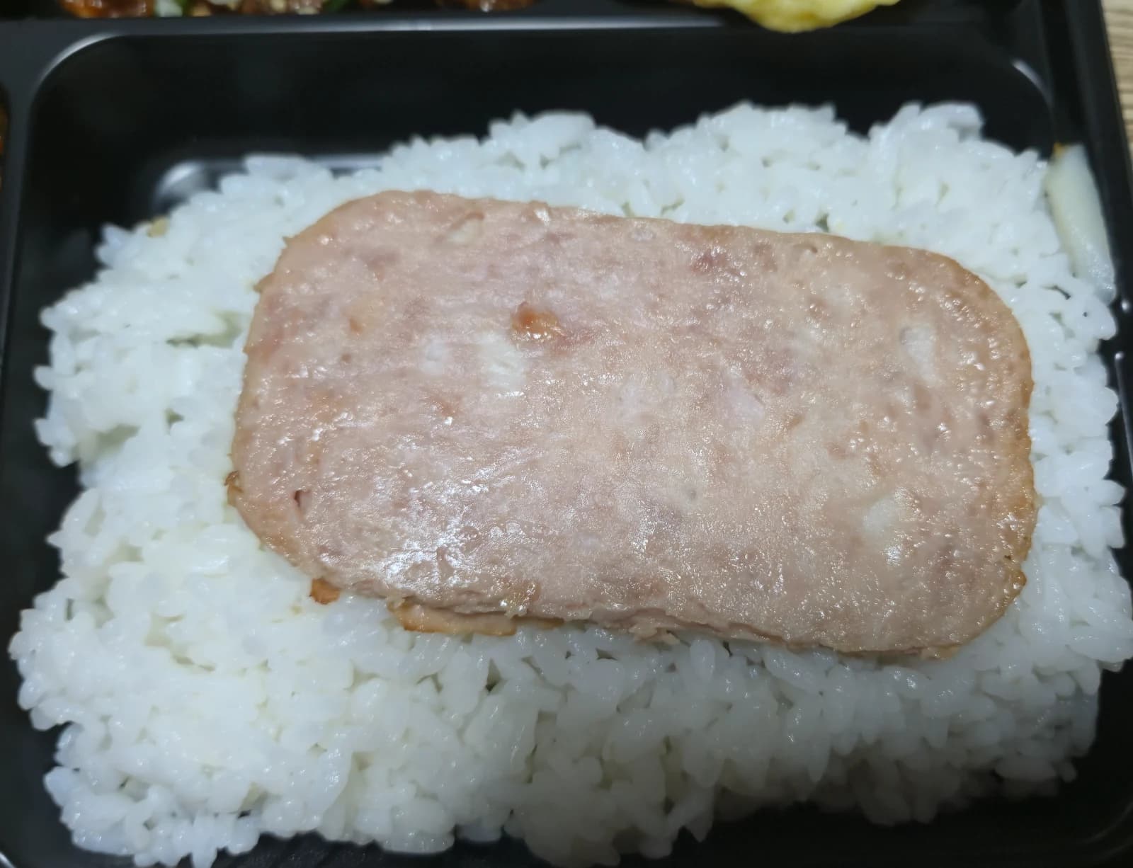 コンビニ弁当 ごはんの上にスパムが1枚乗った状態