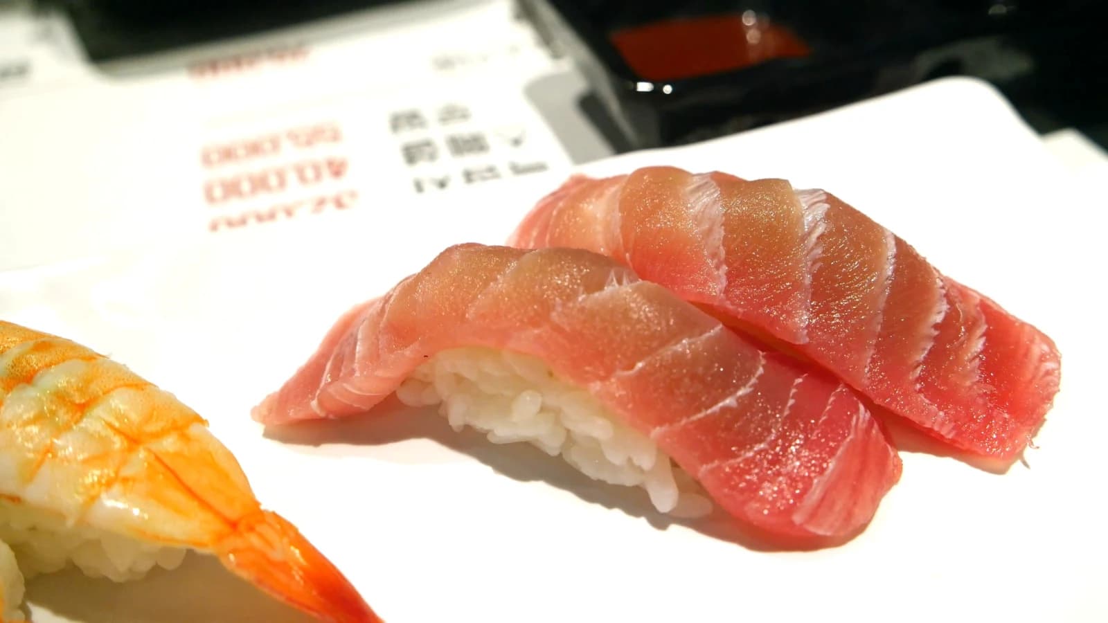 Tuna nigiri sushi with a thick slab of deep red tuna draped over seasoned rice