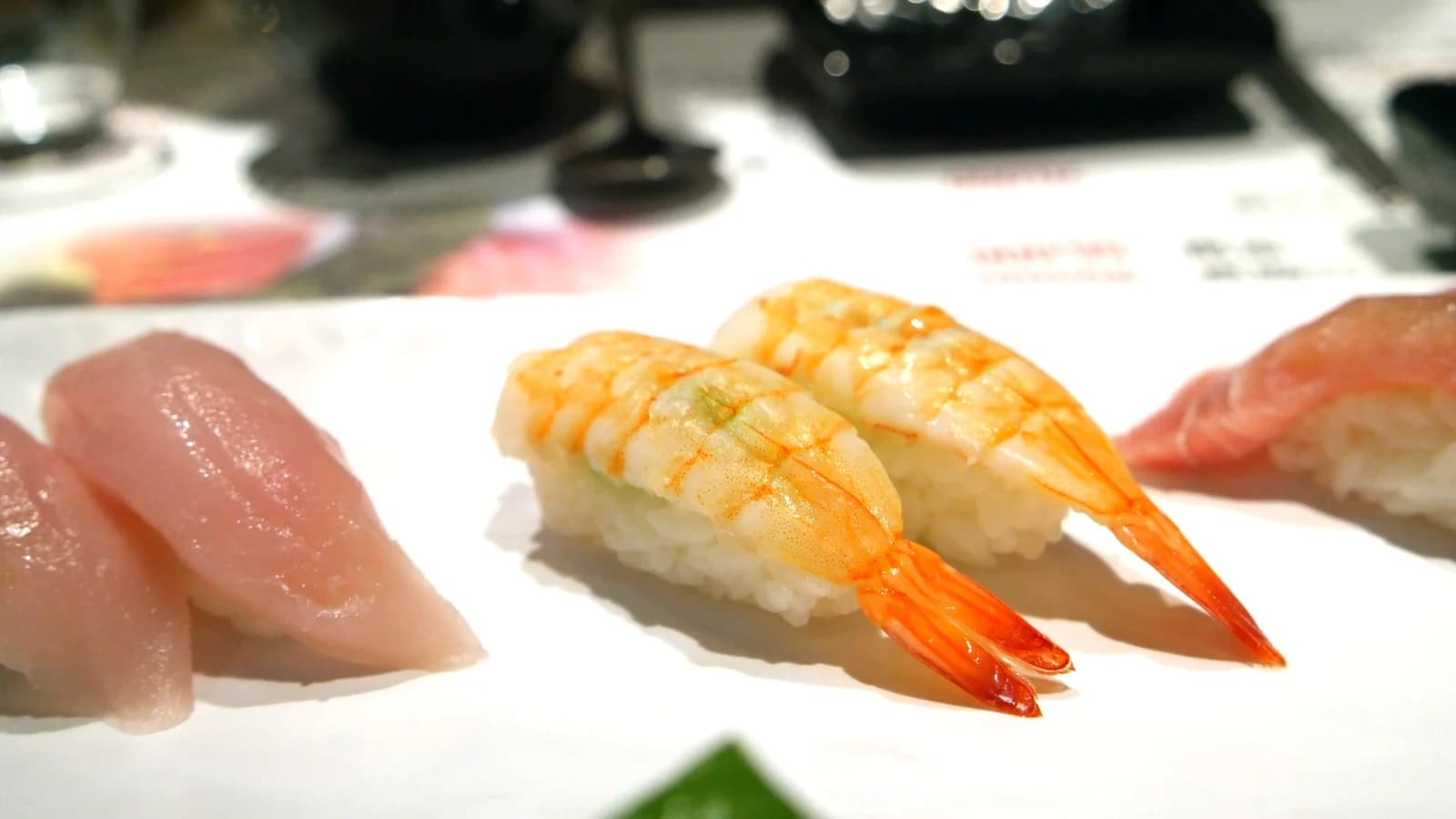 Shrimp nigiri sushi with a whole poached shrimp including tail pressed onto rice