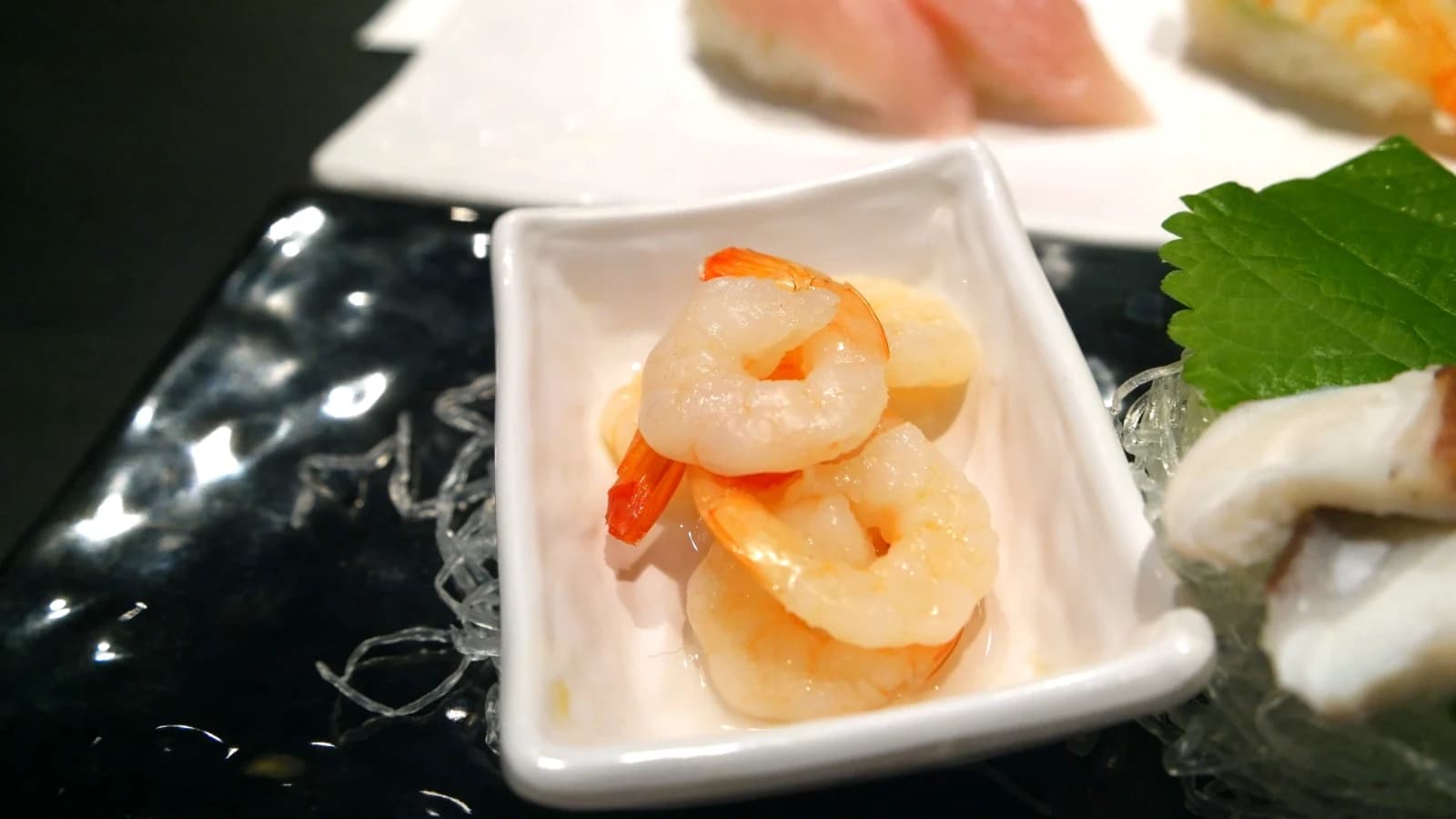 Small dish of plump translucent raw shrimp served without sauce