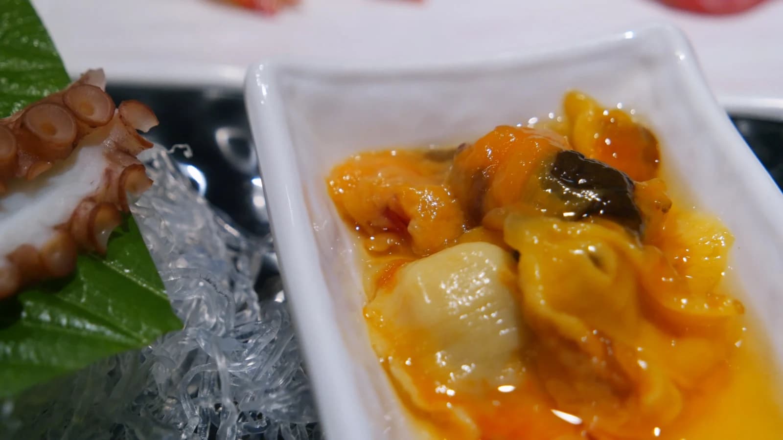 Small dish of bright orange sea squirt, a divisive Korean seafood delicacy
