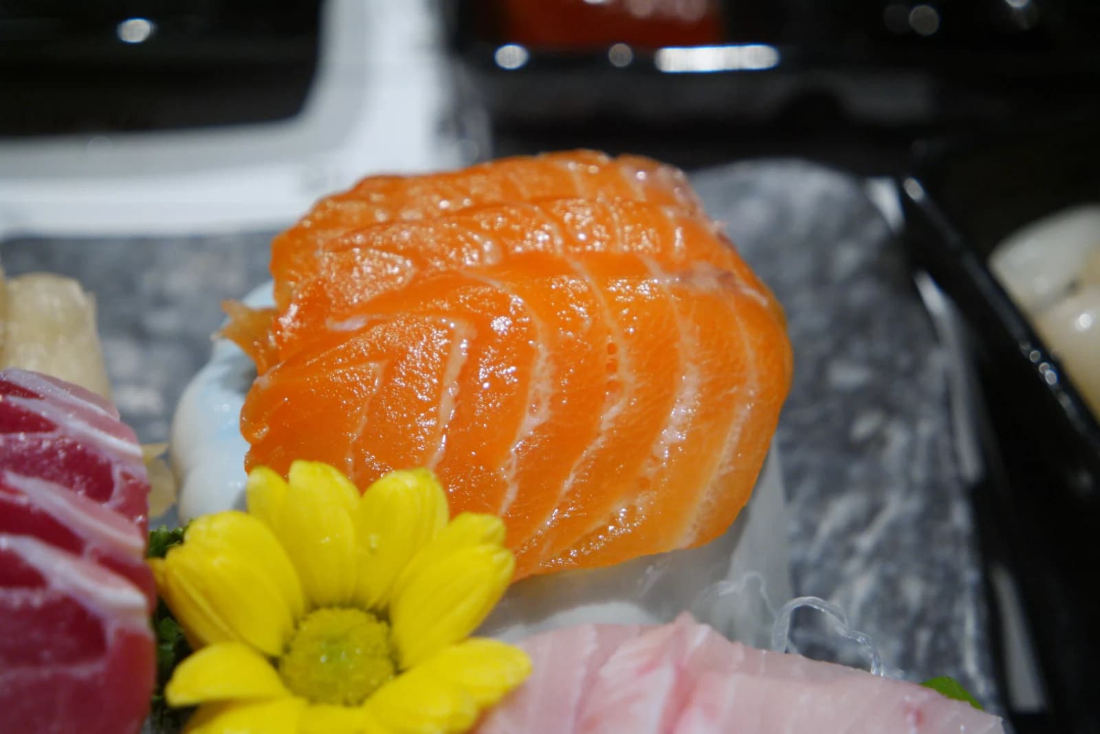 Salmon sashimi with bright orange color and a glistening oily surface