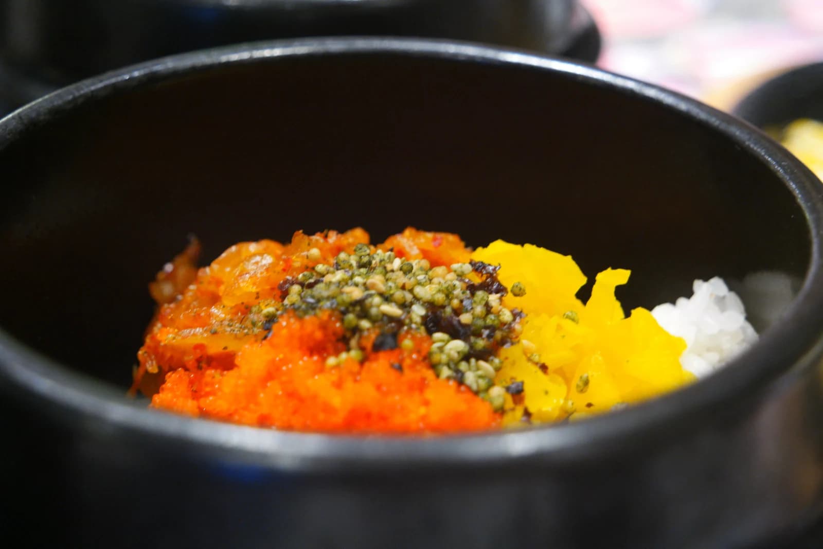 Mixing roe rice with a spoon as flying fish roe blends between the grains of rice